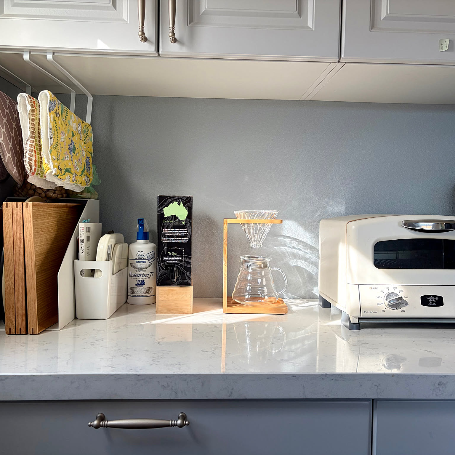 Clean small-kitchen counter with a HARIO V60 stand, tray, and toaster nearby.