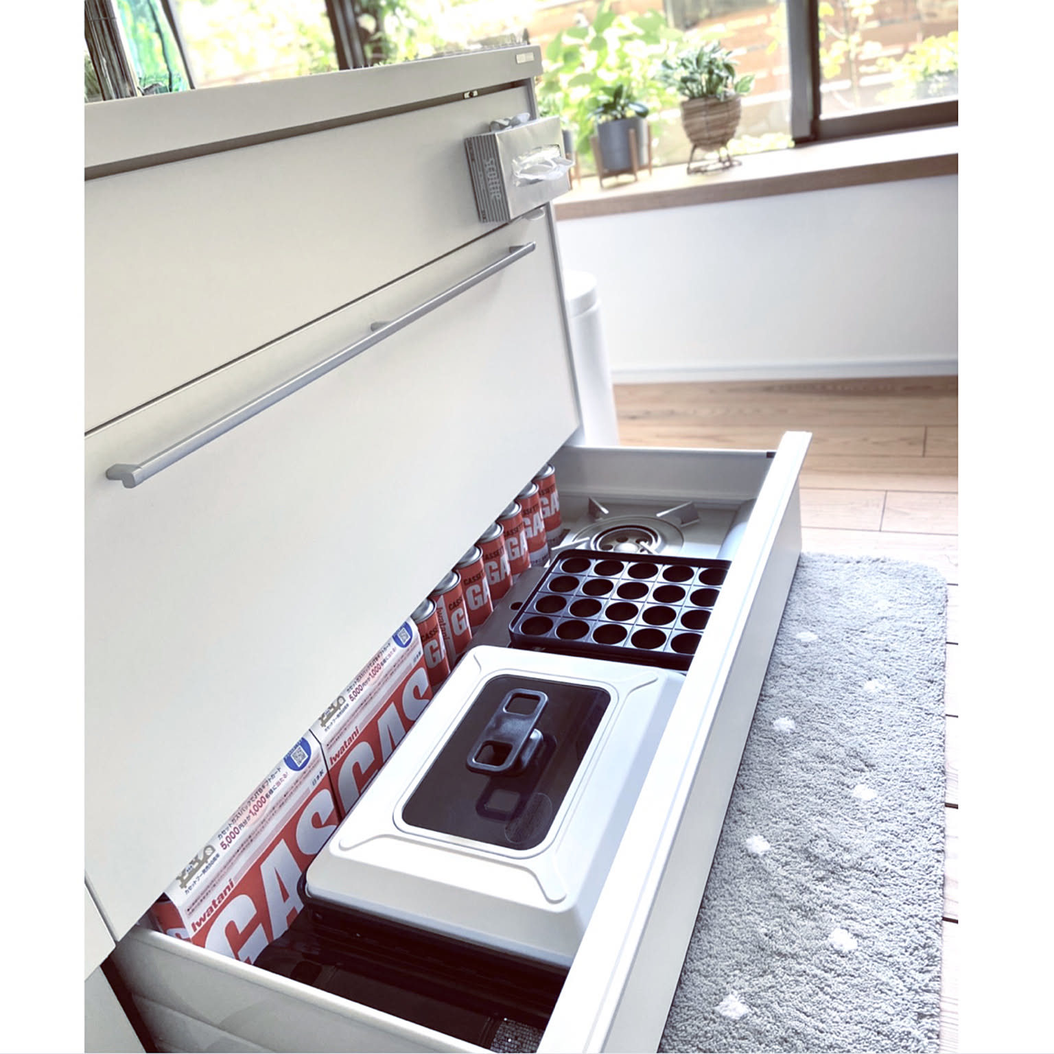 An Iwatani takoyaki grill and gas canisters stored neatly in a kitchen drawer.