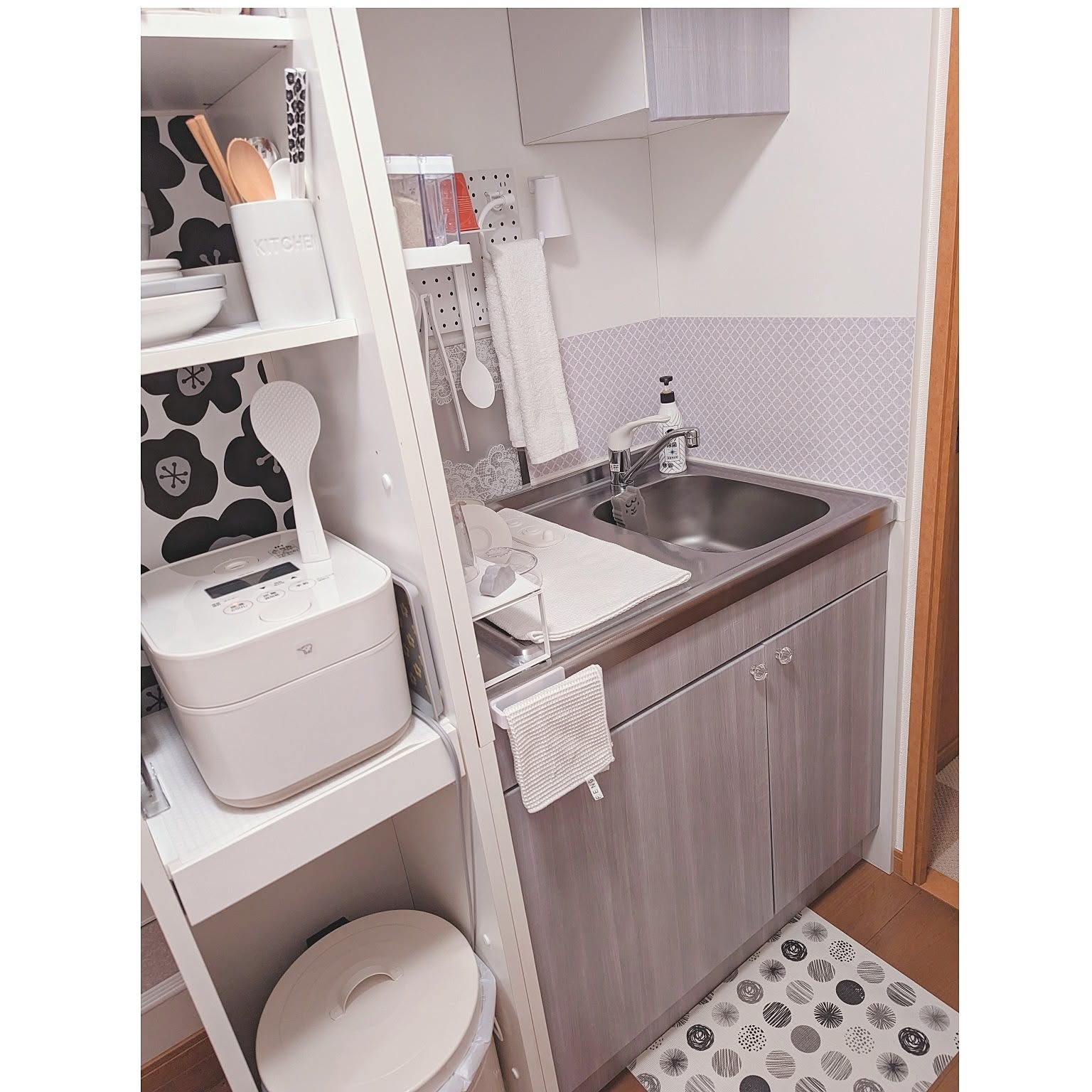 A white Zojirushi STAN. 5.5-cup rice cooker placed in a very compact one-room kitchen.