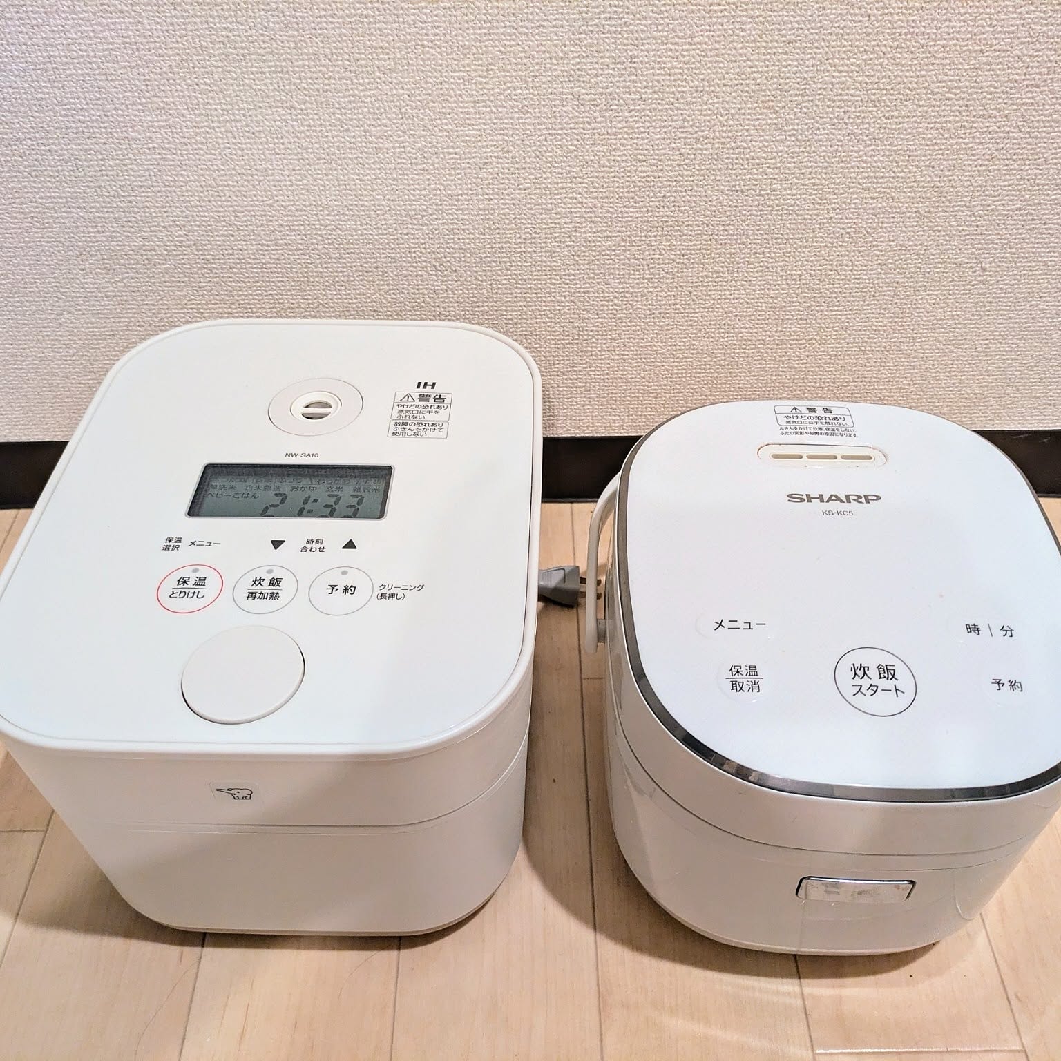 Two white rice cookers placed side by side for a footprint comparison.