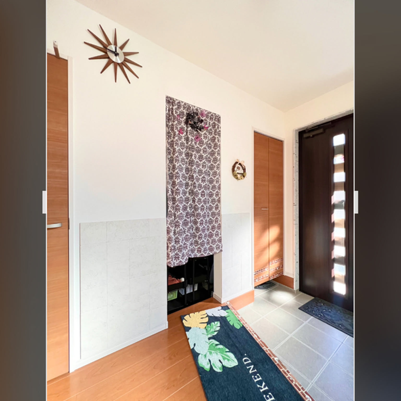 A bright Japanese entryway with a clear floor and shoes stored out of sight so the front door area stays easy to clean.