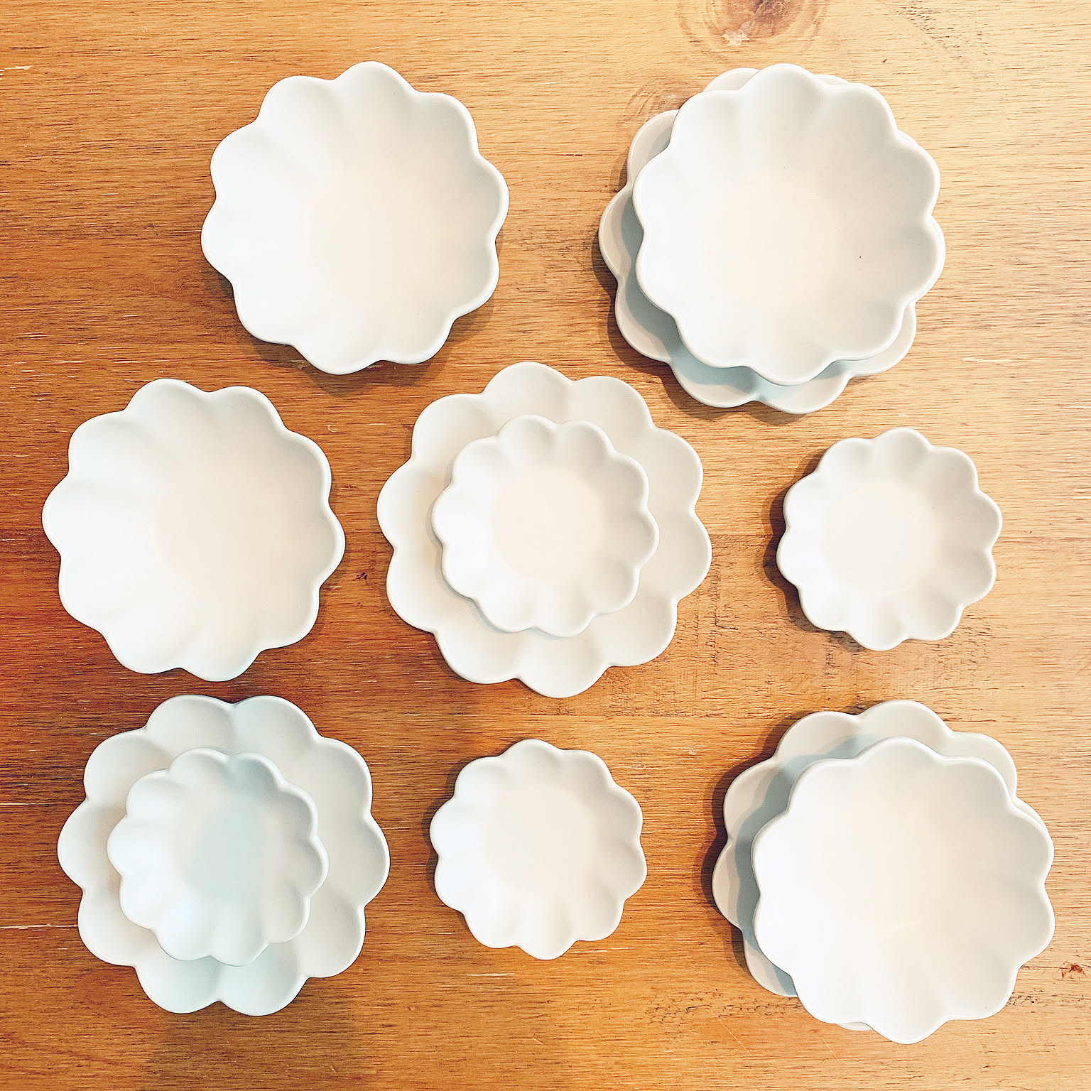 White flower-shaped Japanese small plates in several sizes.