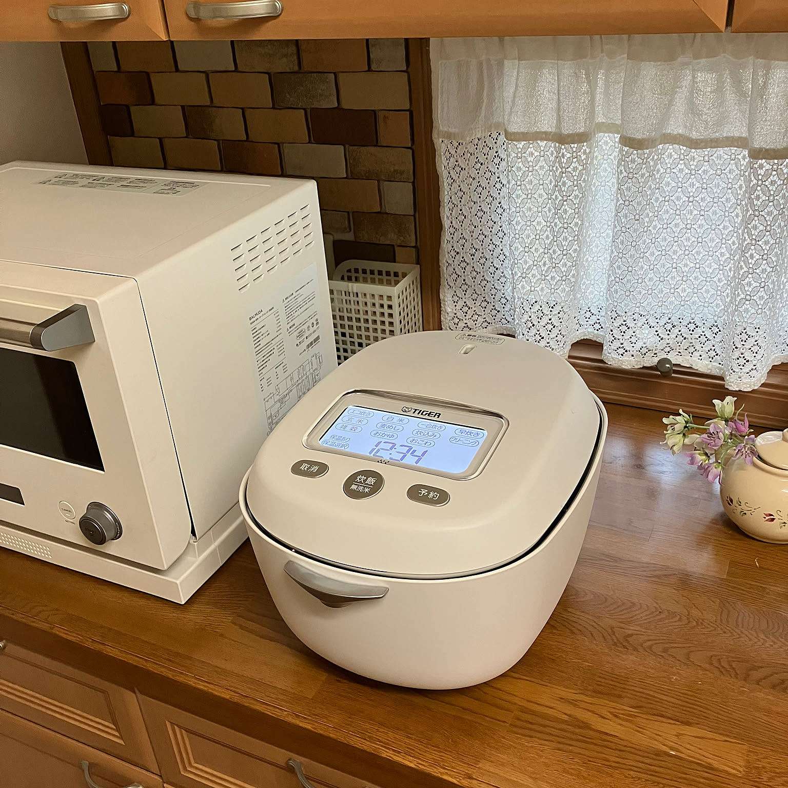 A white Tiger clay-pot pressure IH rice cooker shown clearly on a wooden counter.