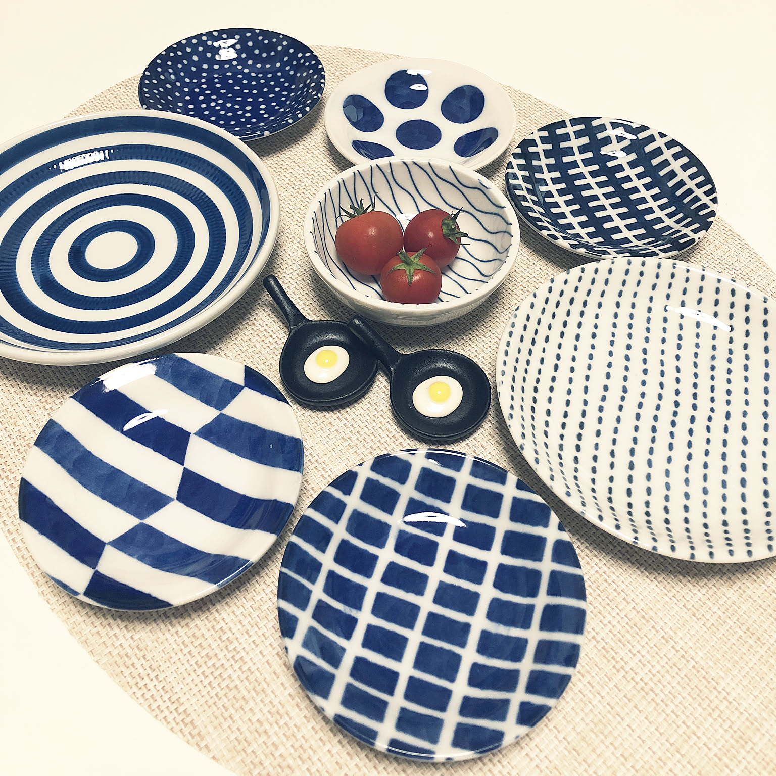 Blue and white Japanese small plates in mixed patterns on a round mat.