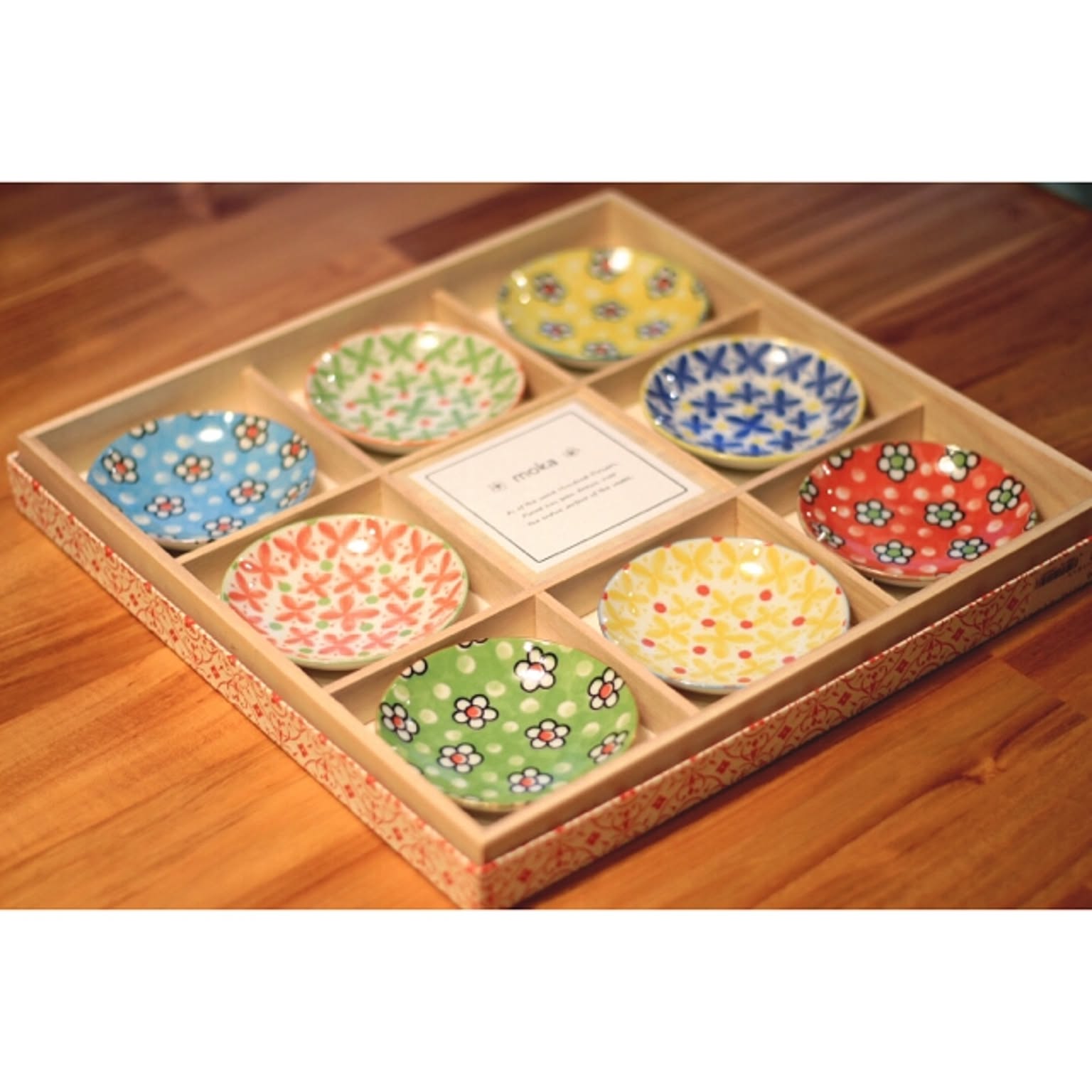 Colorful small Japanese plates arranged in a divided gift box.