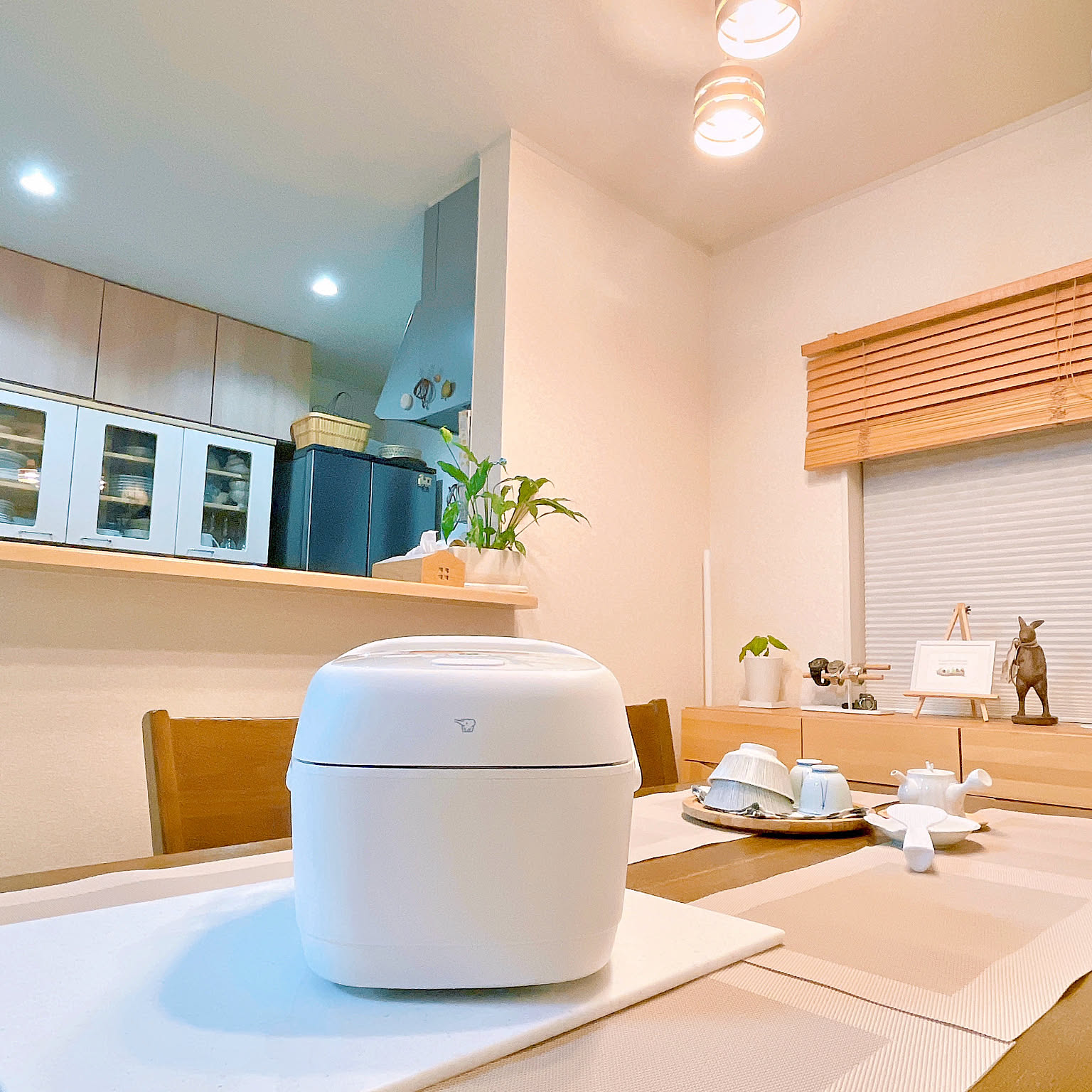 A white Zojirushi pressure IH rice cooker placed prominently on a dining table.