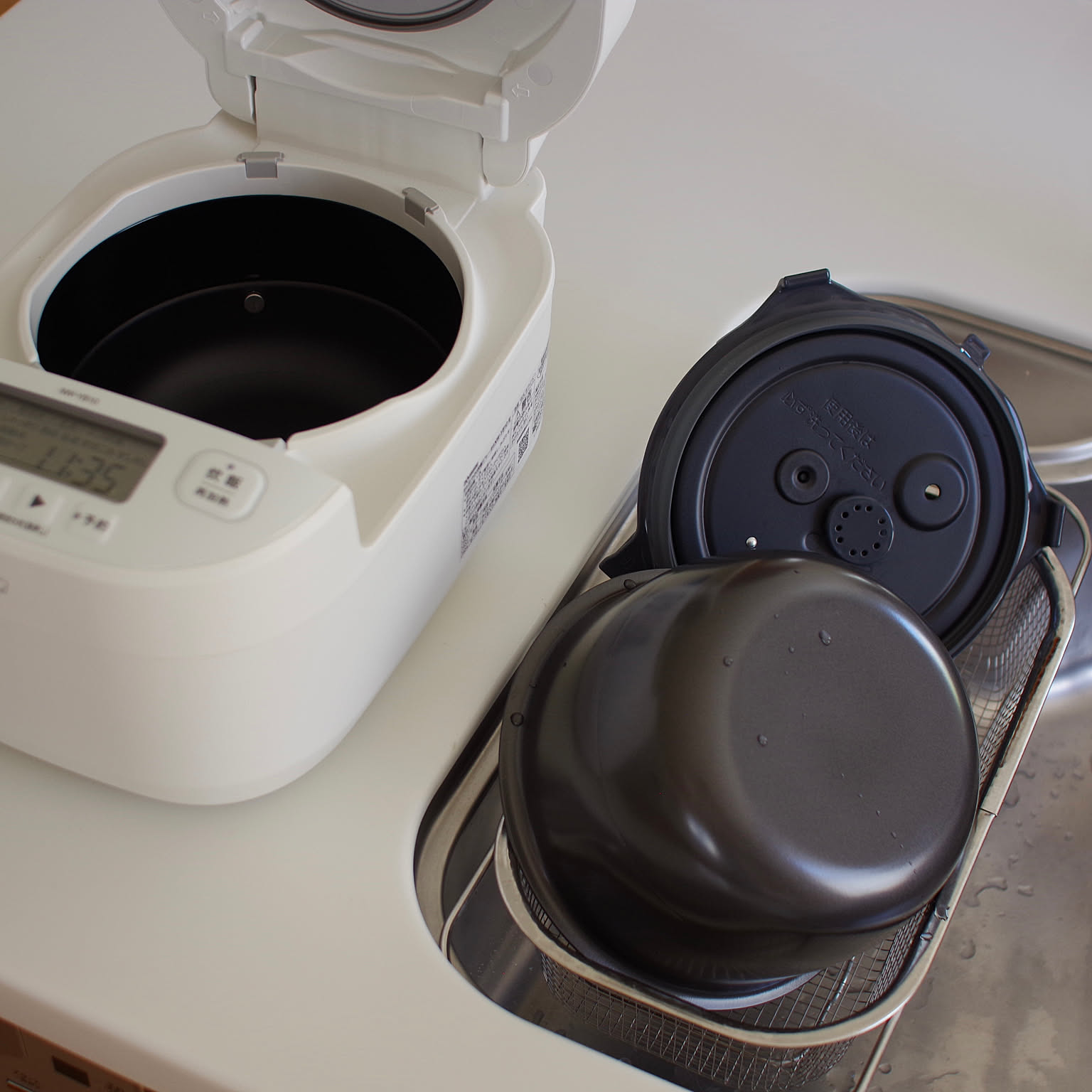 A white Zojirushi pressure IH rice cooker opened to show the inner lid and inner pot.