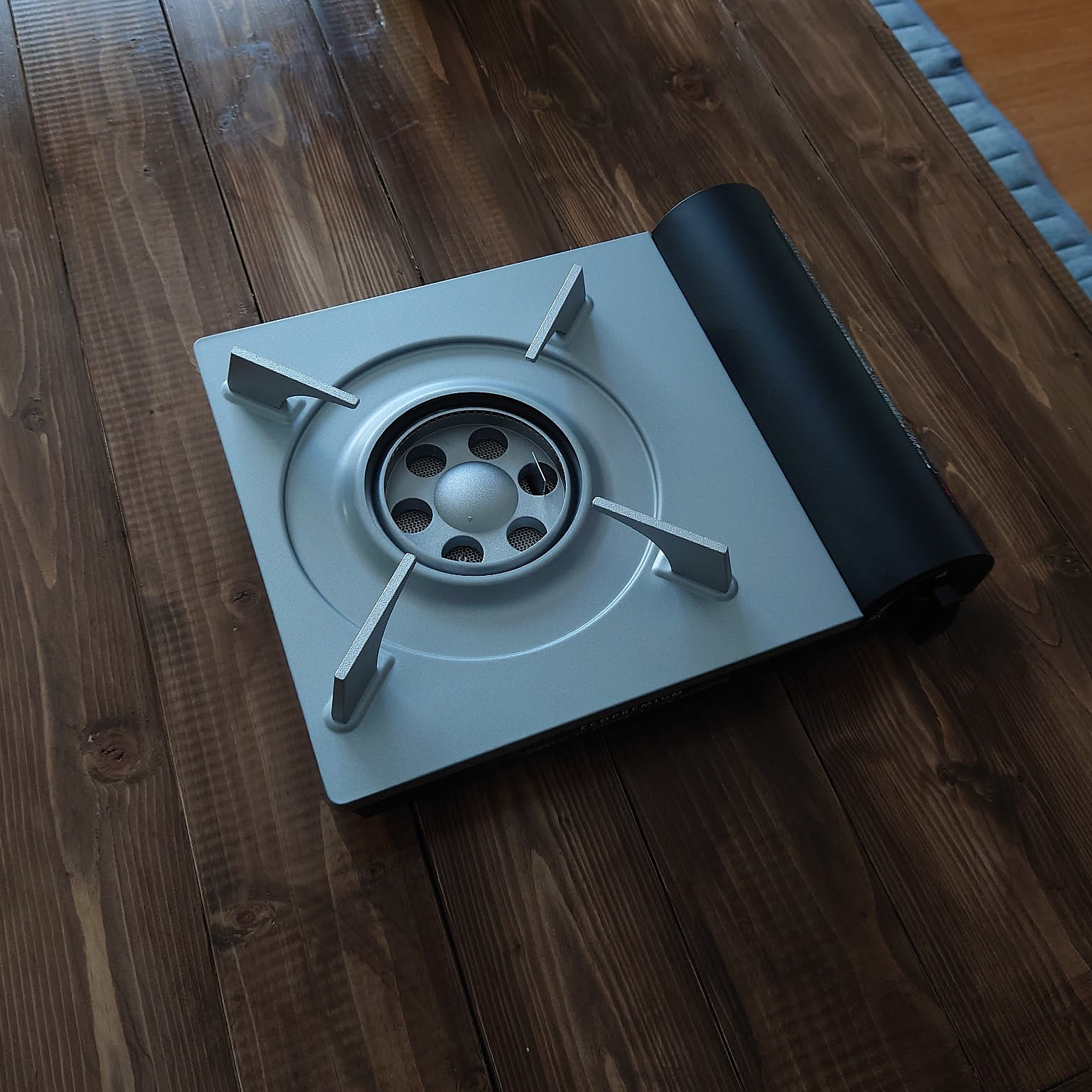 An Iwatani Eco Premium cassette stove shown clearly on a wood table.