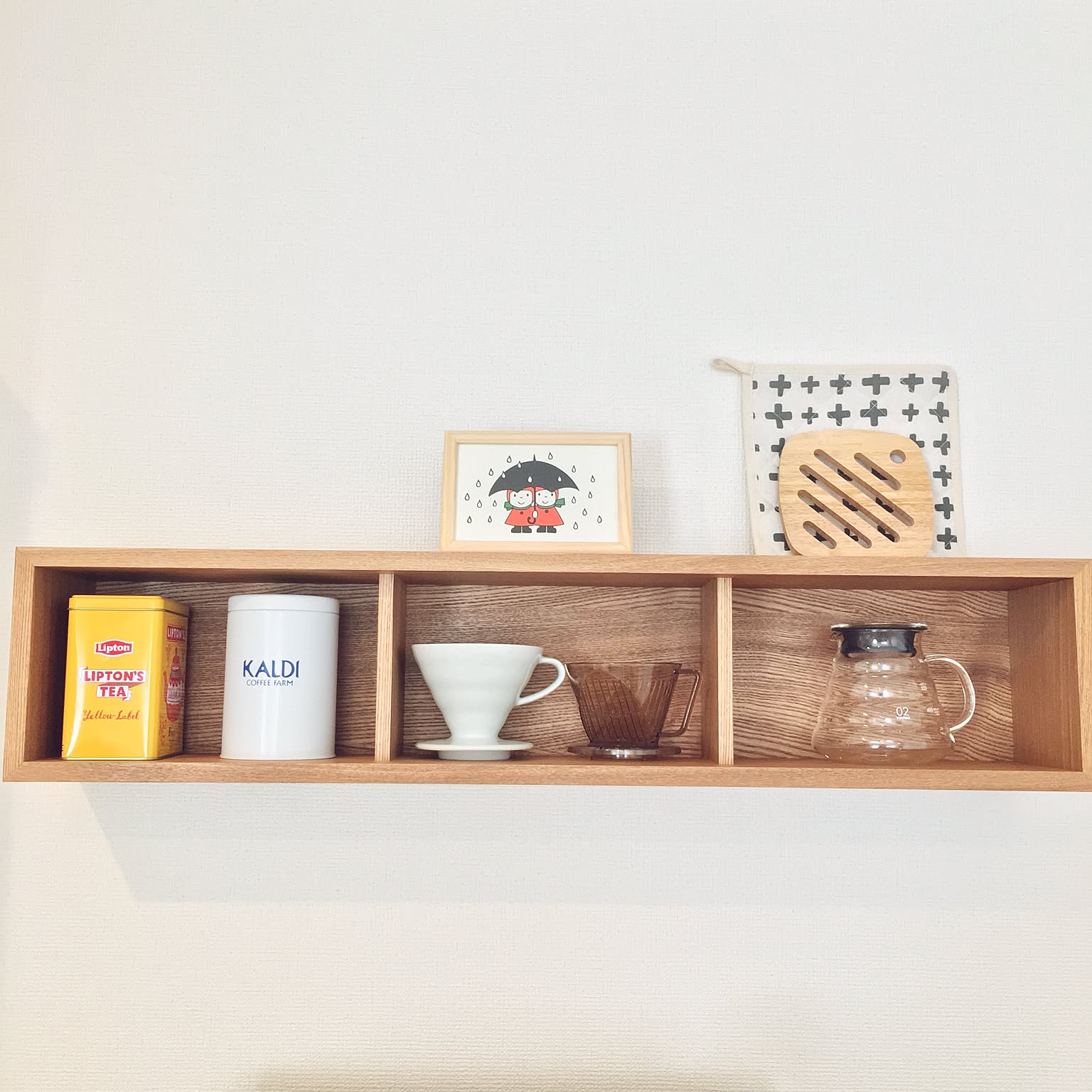 Wall shelf with HARIO V60 dripper, server, coffee tins, and small storage.