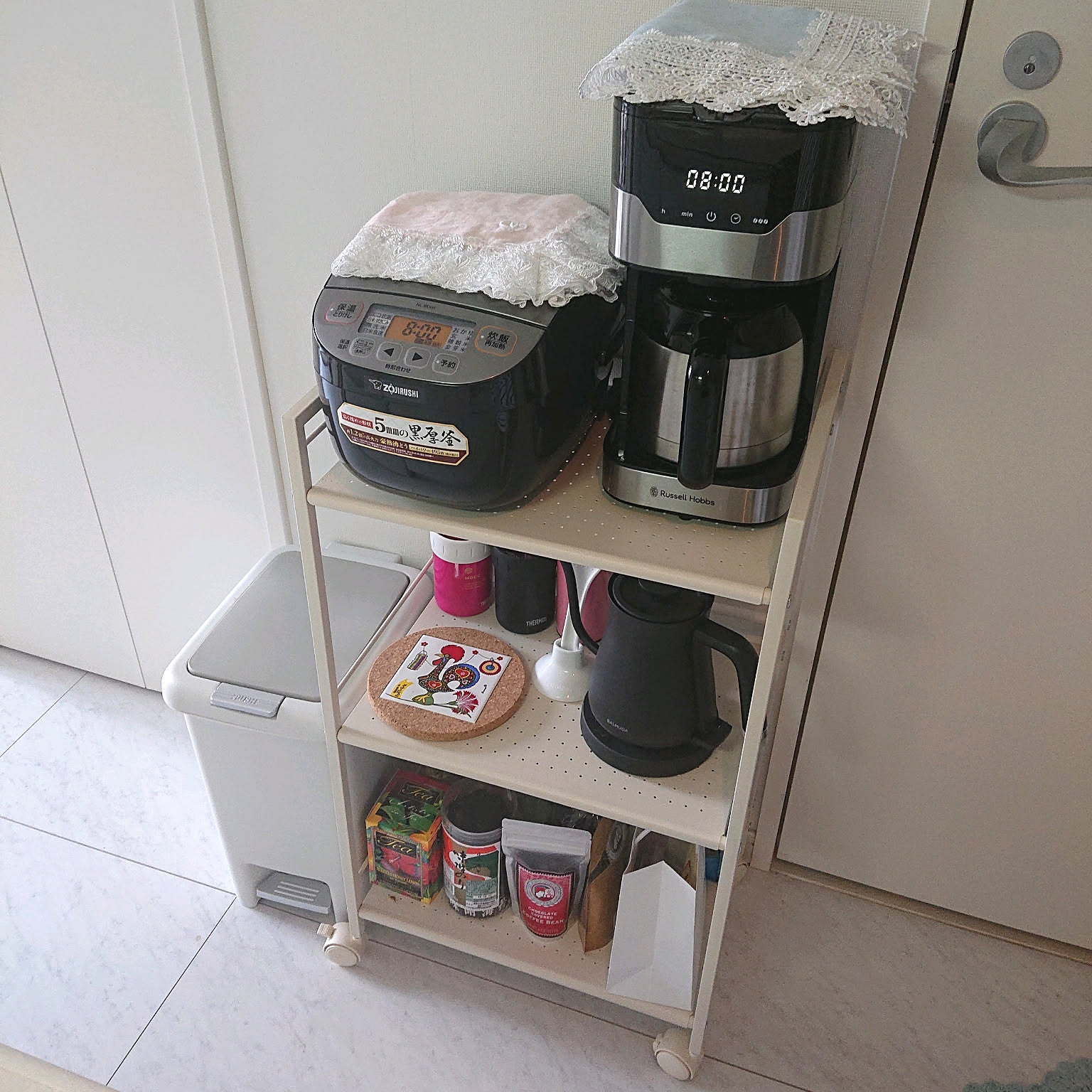 A black Zojirushi 3-cup micom rice cooker on a narrow kitchen wagon.