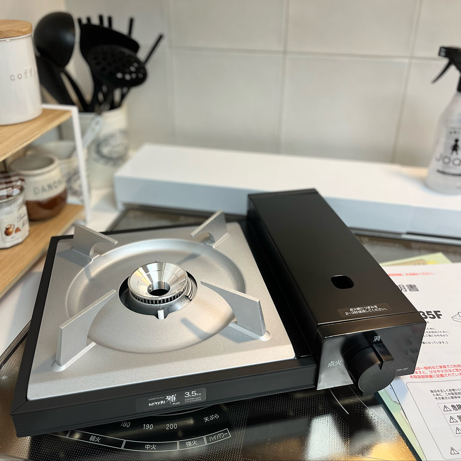 A black Iwatani cassette stove shown clearly on a kitchen counter with its manual.
