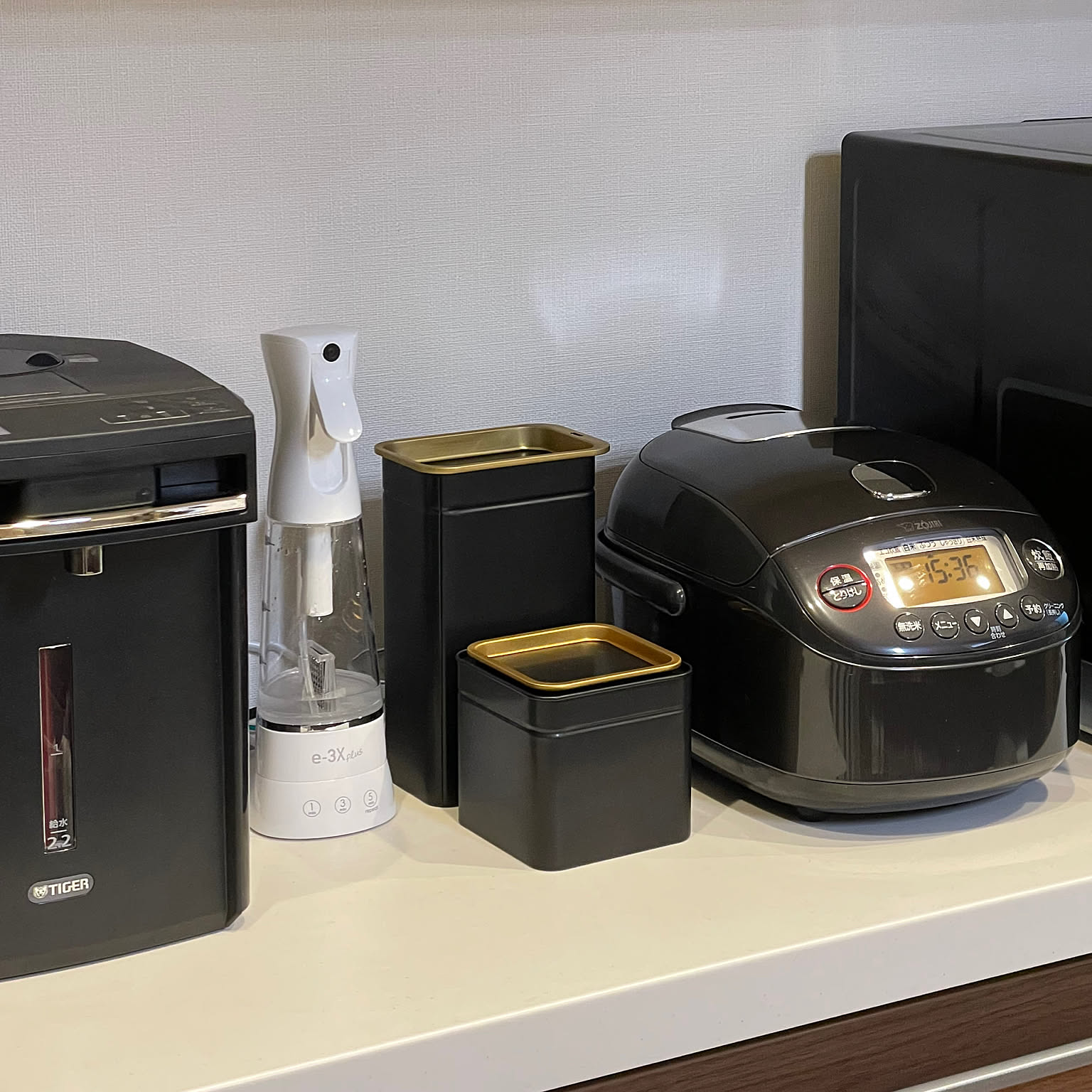 A black Zojirushi 3-cup rice cooker arranged with other black kitchen appliances.