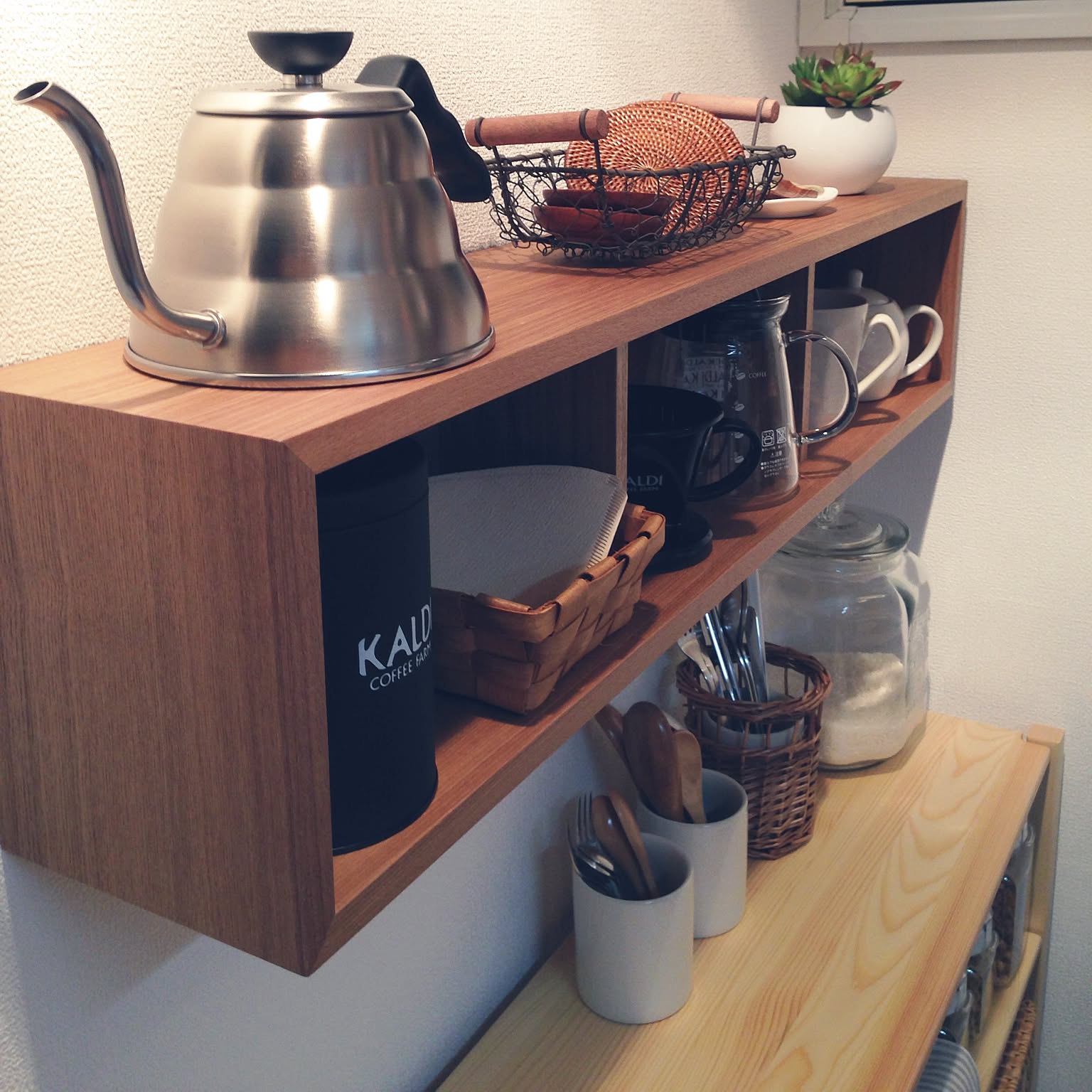 A Hario V60 Buono kettle stored on a compact wall shelf in a Japanese kitchen coffee zone.