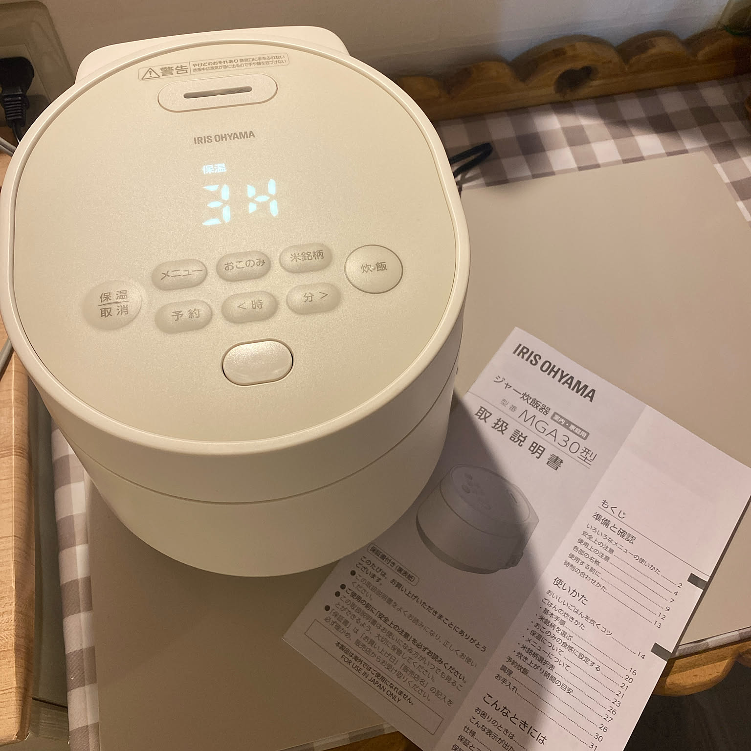 A compact white 3-cup rice cooker shown from above on a narrow counter.