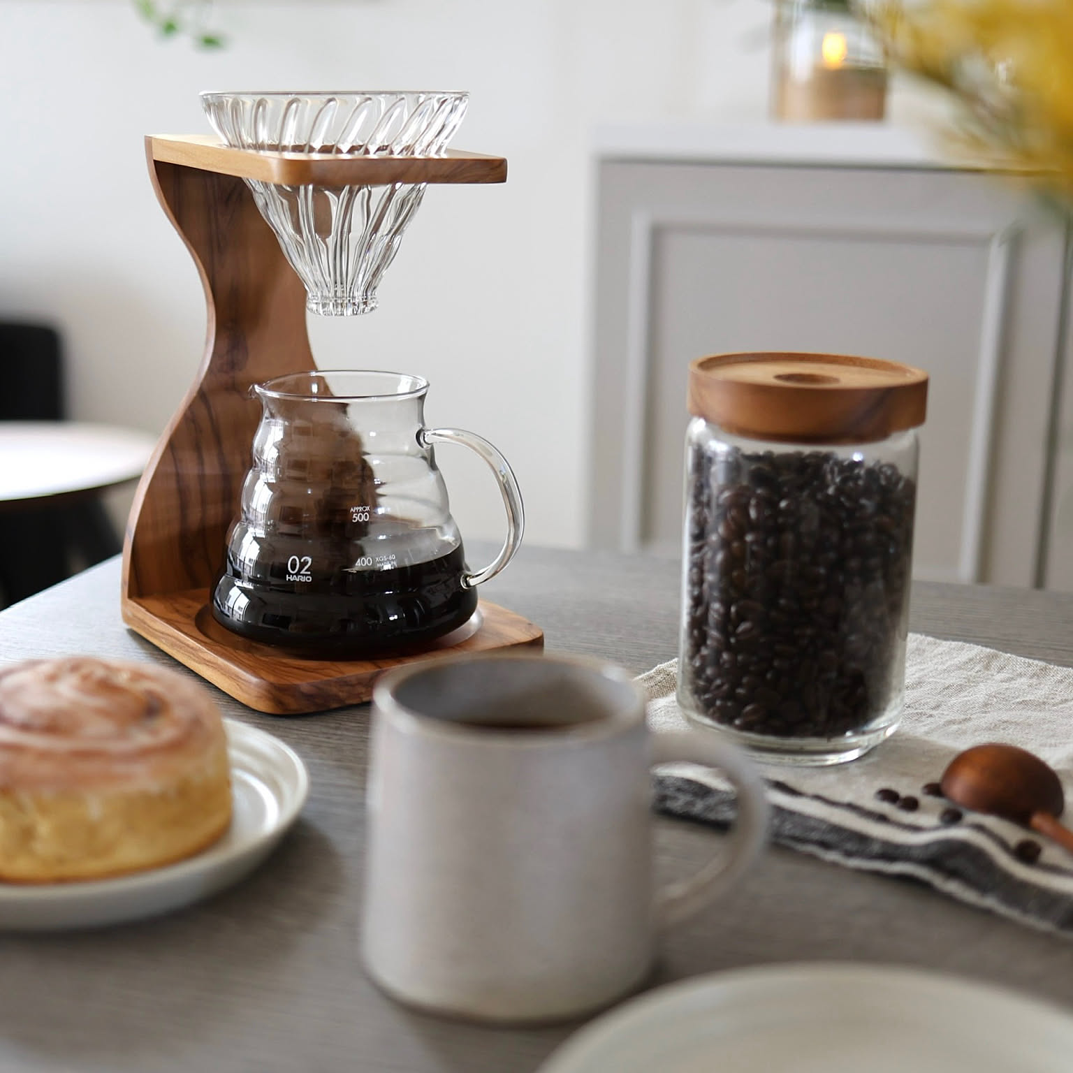 HARIO V60 olive wood stand set with glass dripper, server, coffee beans, and cup.