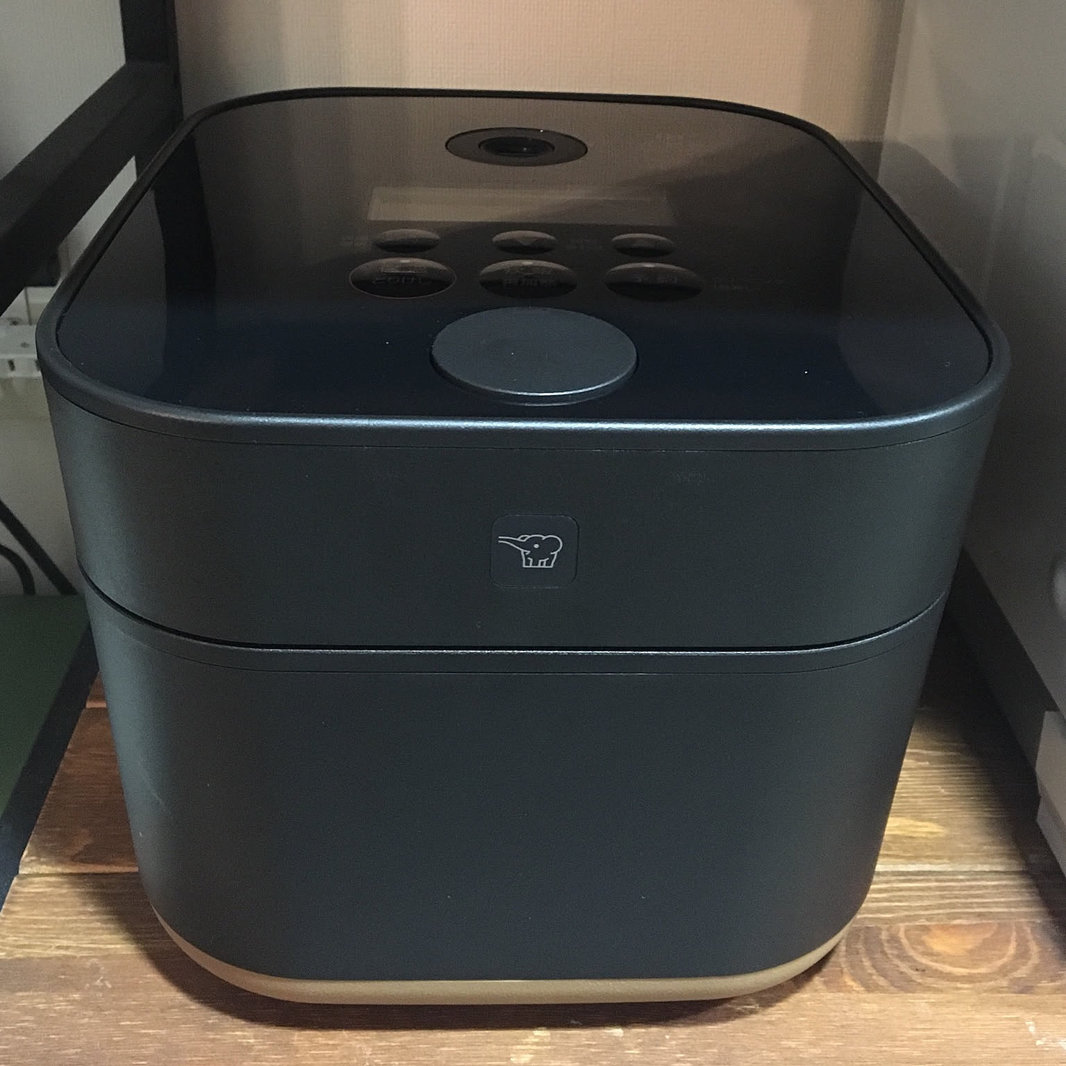 A black Zojirushi STAN. 5.5-cup rice cooker shown prominently in close-up.