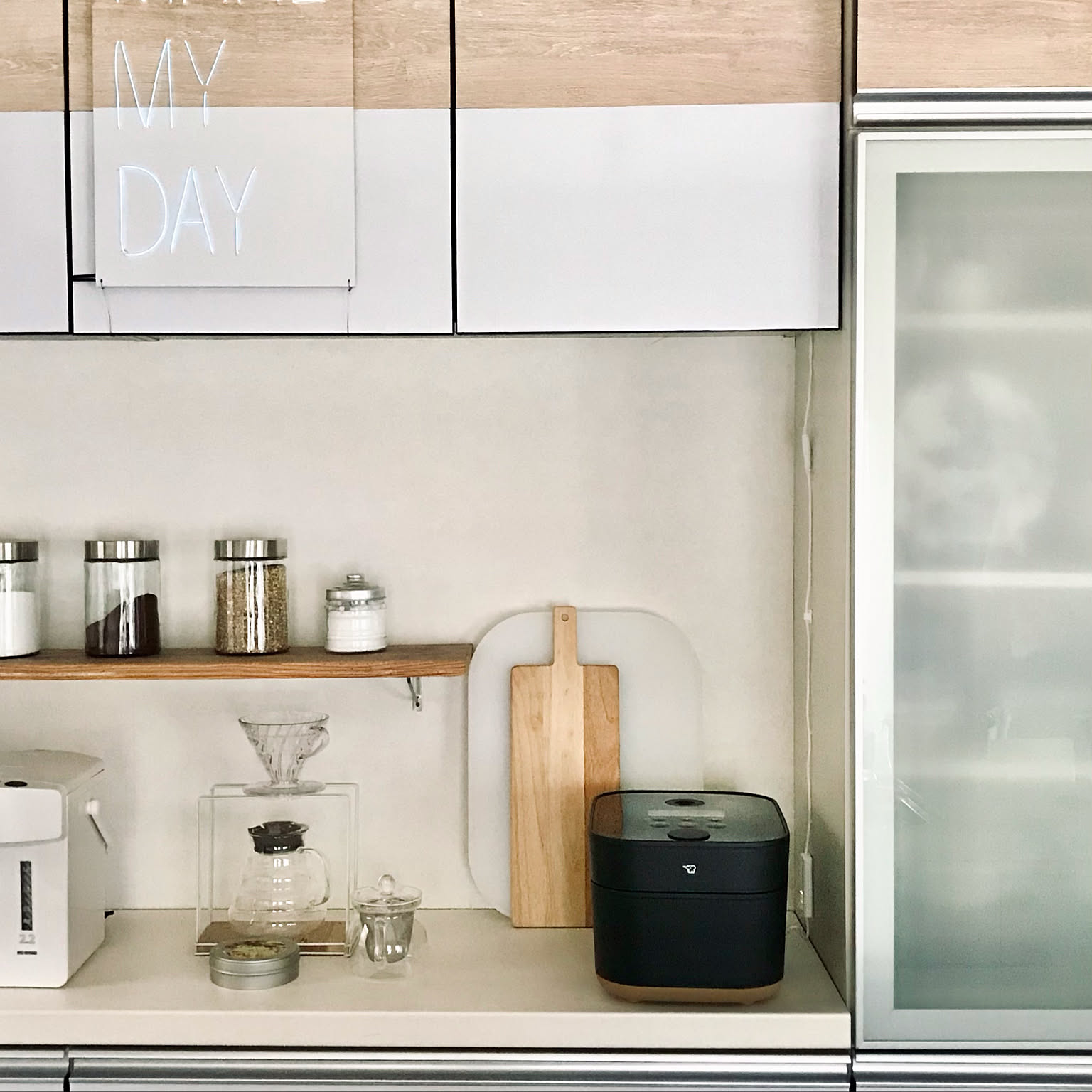 A black Zojirushi STAN. rice cooker shown prominently on a Japanese kitchen counter beside coffee gear.