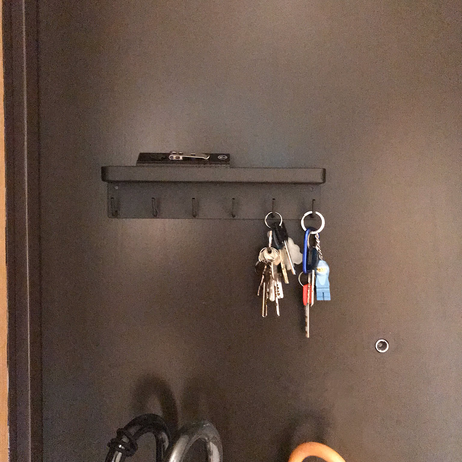 A magnetic key rack installed on an apartment entry door in a Japanese home.