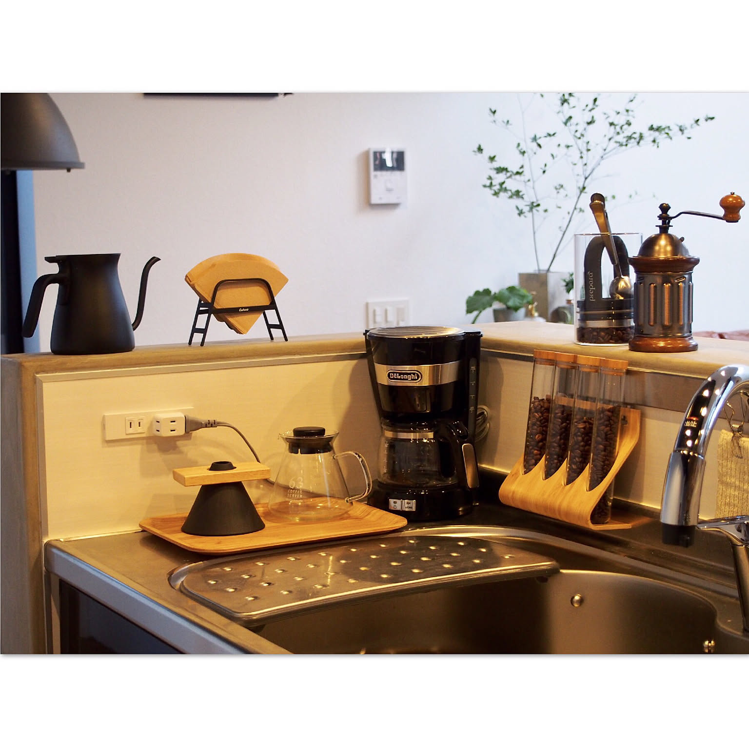 Coffee corner using wall rails, jars, shelves, and compact counter storage.