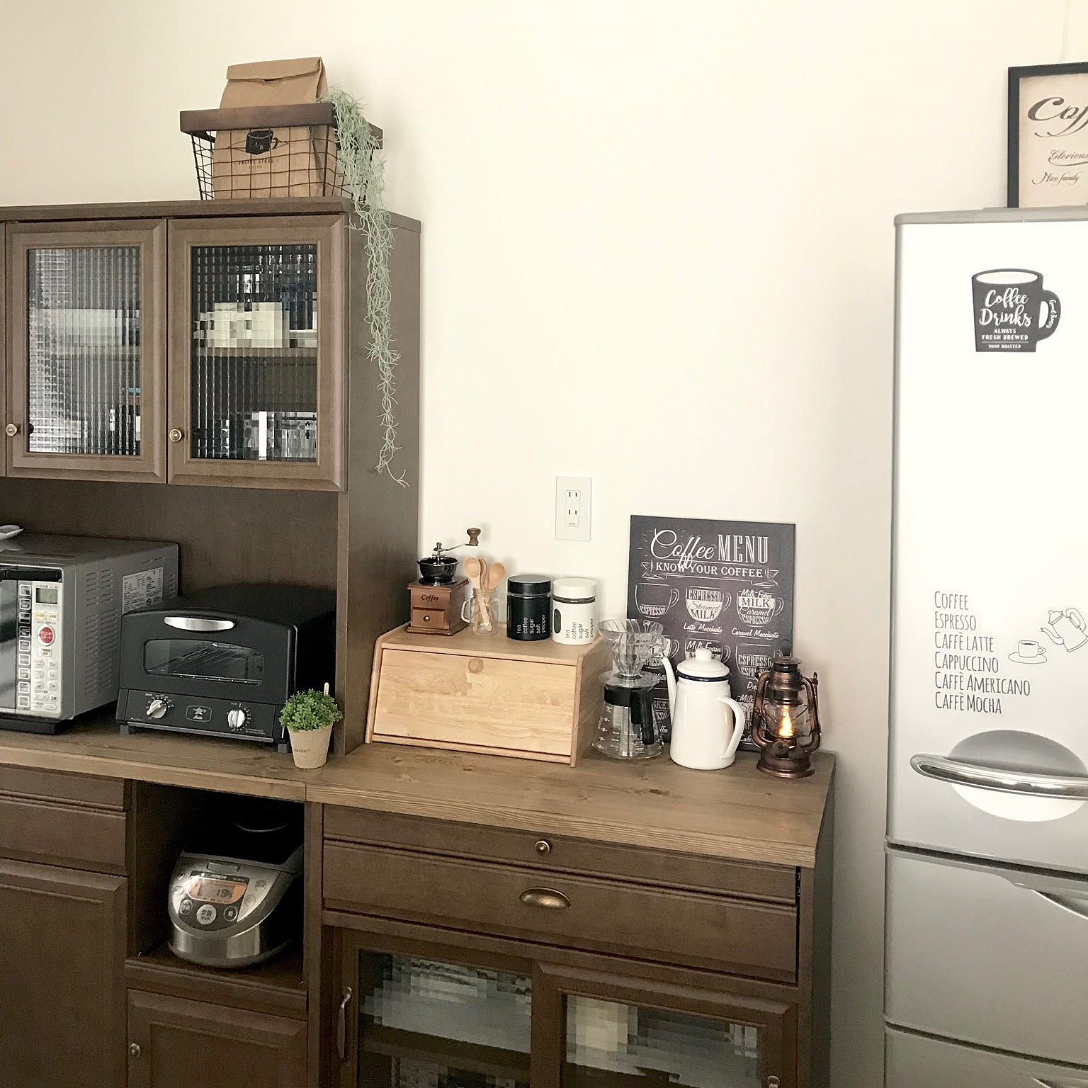 A compact coffee corner with a clear HARIO V60 dripper, glass server, grinder, and small kitchen appliances.