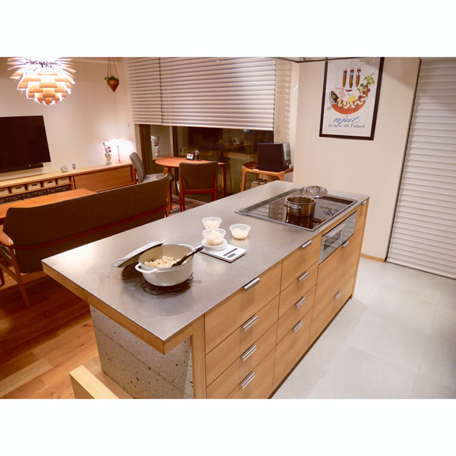 Cooked brown rice being portioned into a small microwave-safe container on a kitchen counter beside a rice cooker.