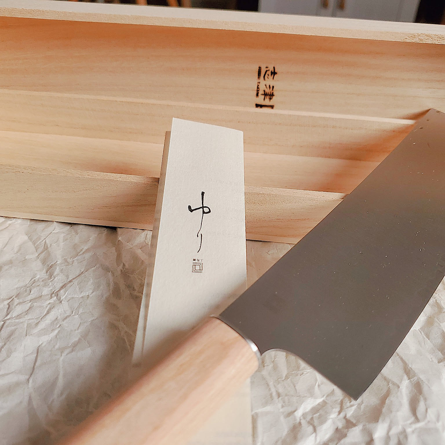 Rectangular Japanese nakiri knife with a wooden handle and storage box.