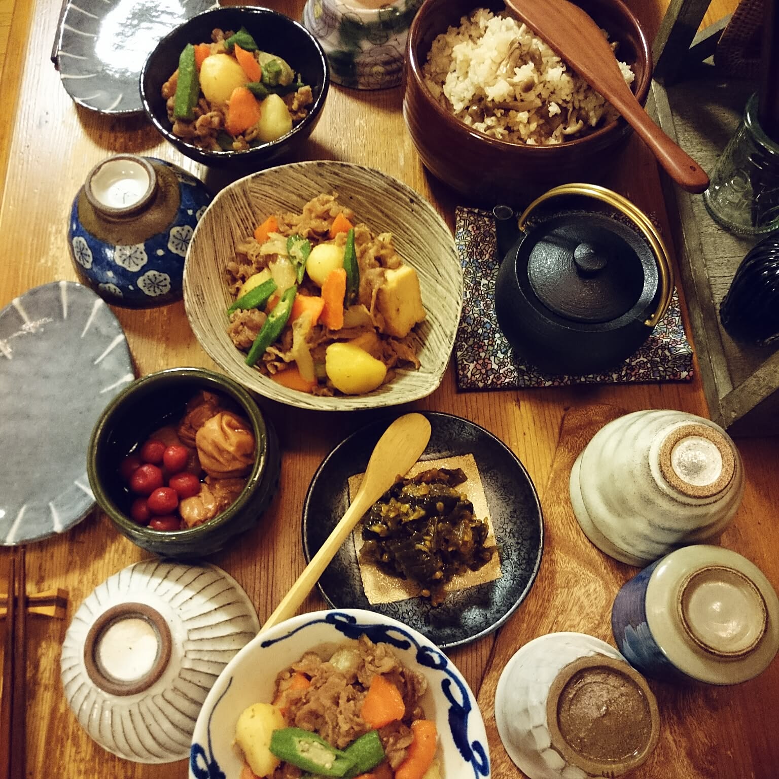 Everyday Japanese meal with rice bowls, simmered dishes, small plates, and a rice pot.