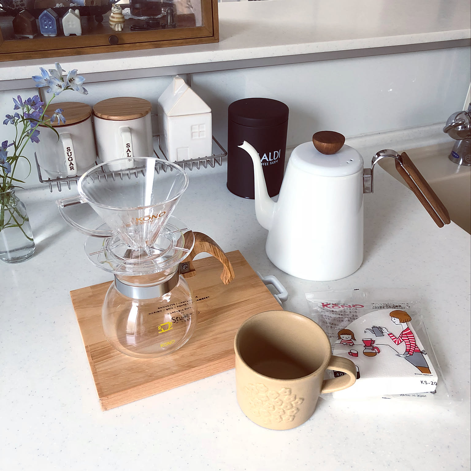 Pour-over workflow with a clear dripper, server, cup, and enamel drip kettle.