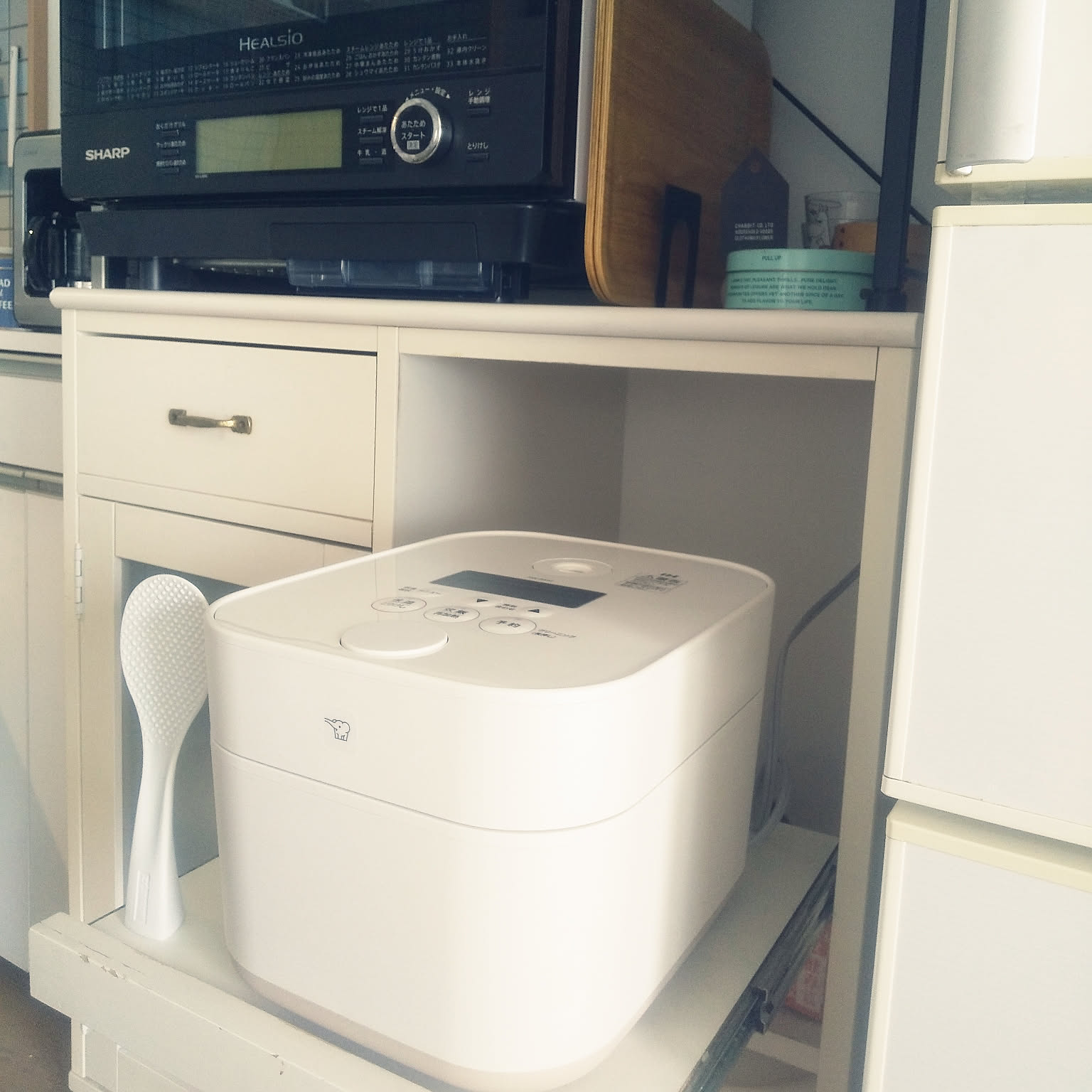 A white Zojirushi STAN. rice cooker placed neatly on a compact kitchen counter.