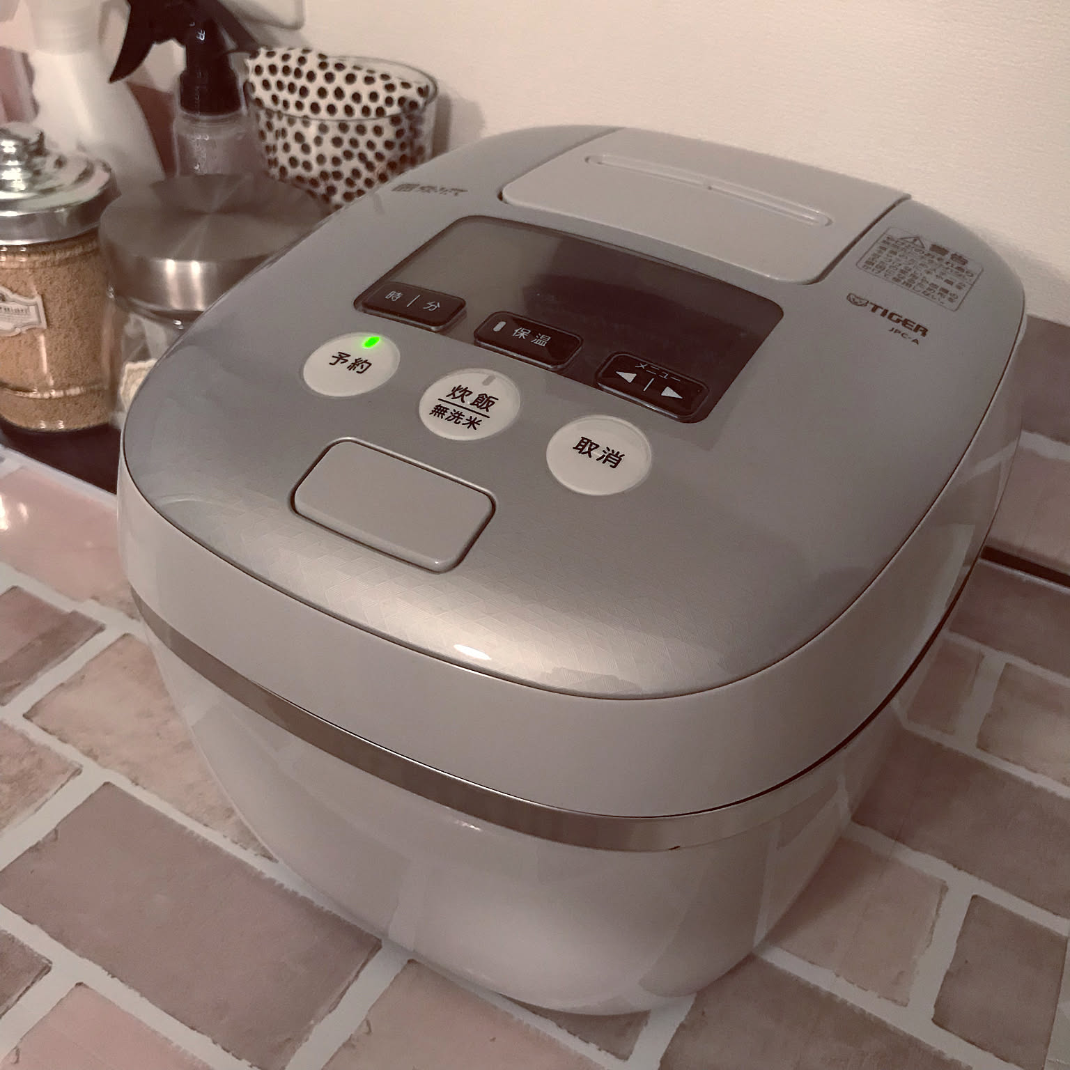 A simple white-and-gray Tiger pressure IH rice cooker shown in close-up.