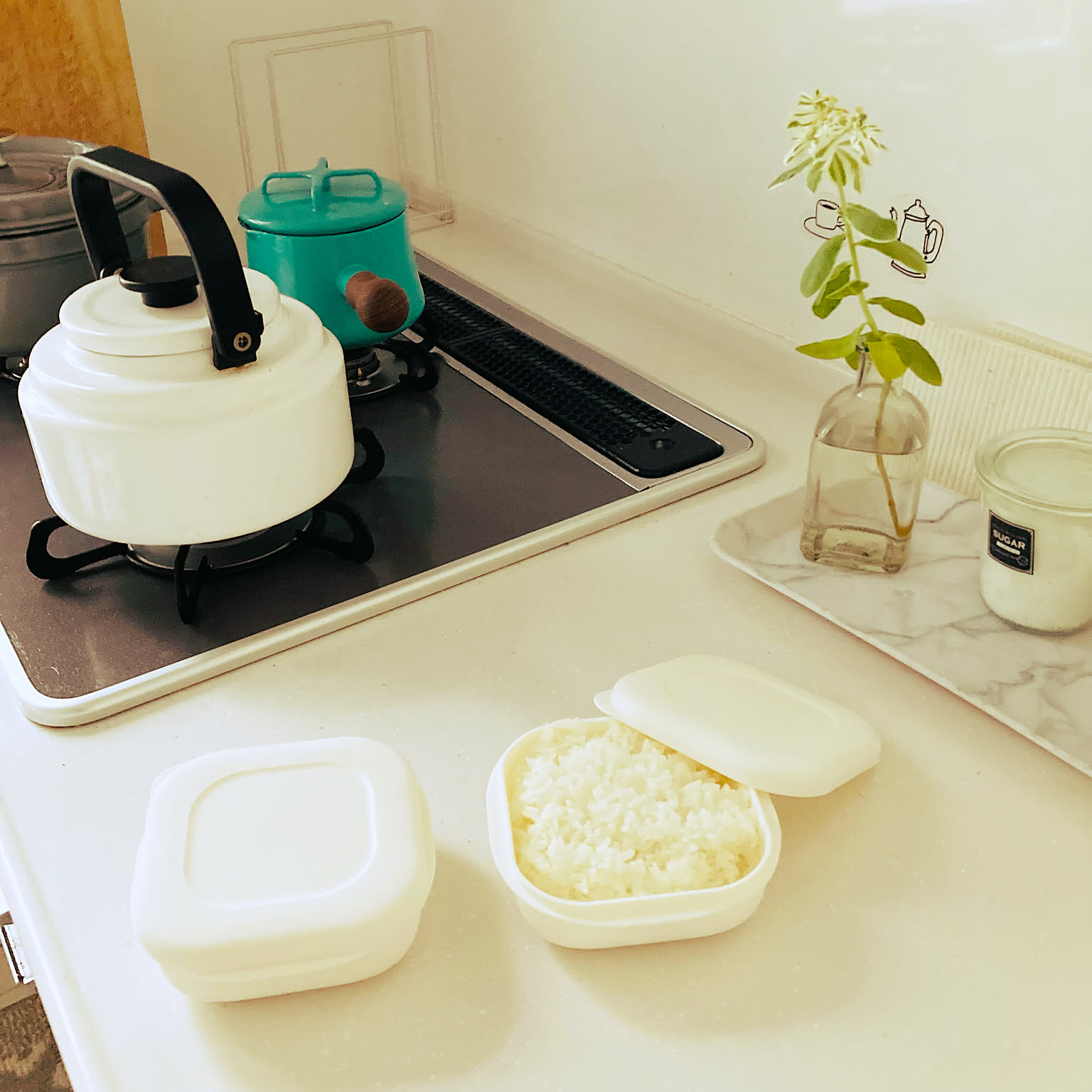 Single-serving rice containers on a kitchen counter, with one lid removed to show the rice inside.