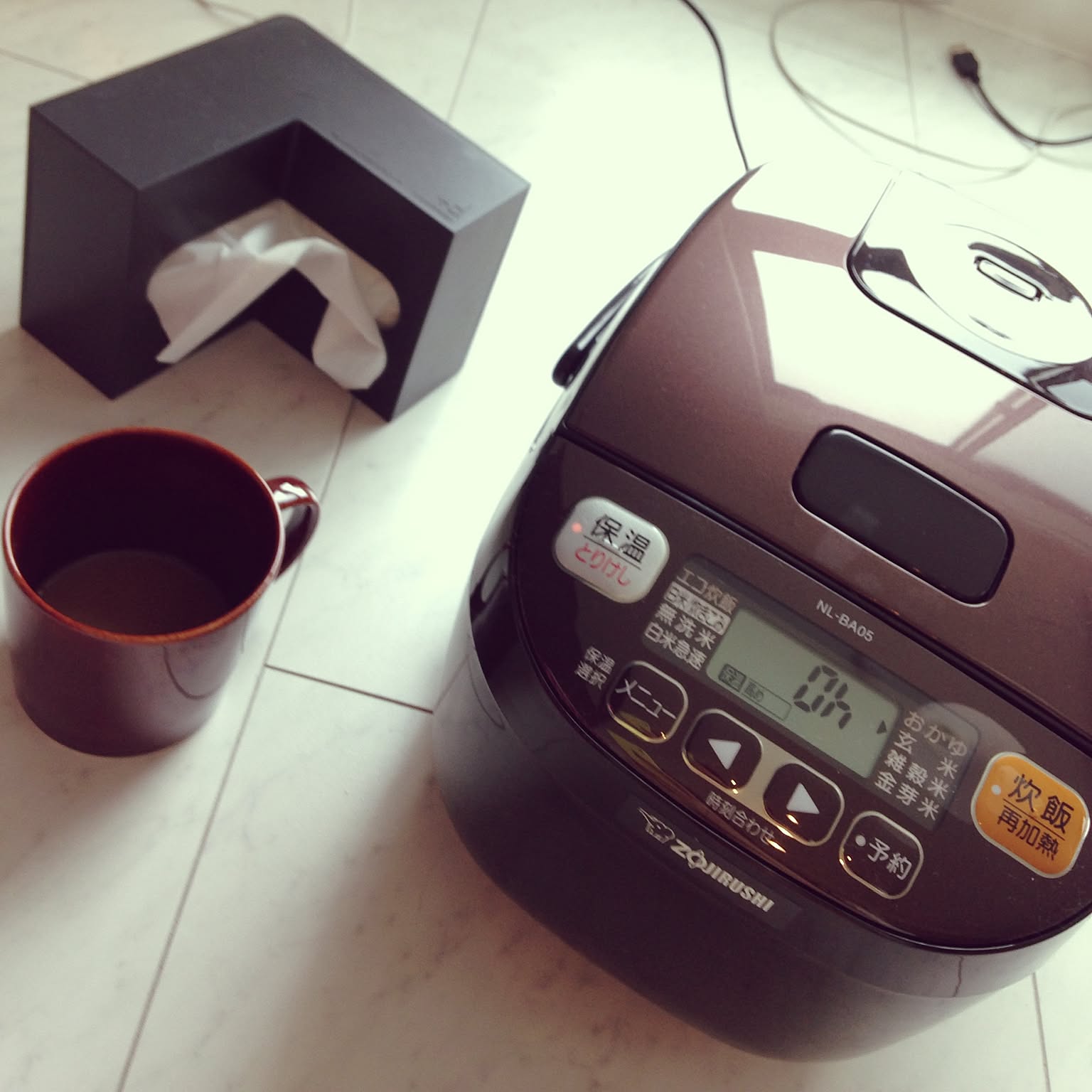 A close-up of a brown Zojirushi 3-cup IH rice cooker with its controls visible.