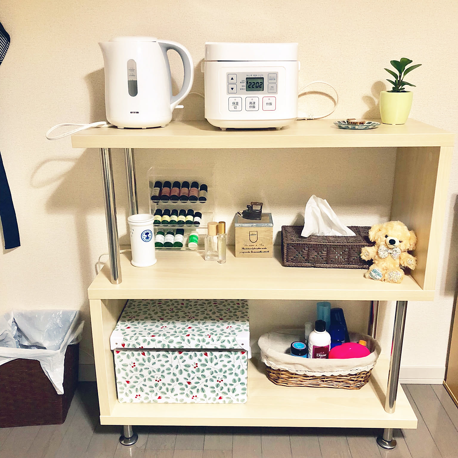 A compact white Nitori three-cup rice cooker and white electric kettle on a small shelf.