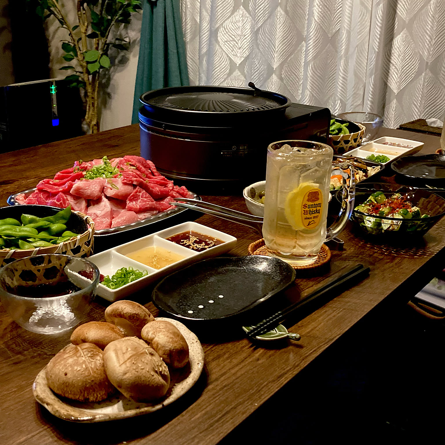 An Iwatani Yakimaru grill set at the center of a prepared indoor dinner table.