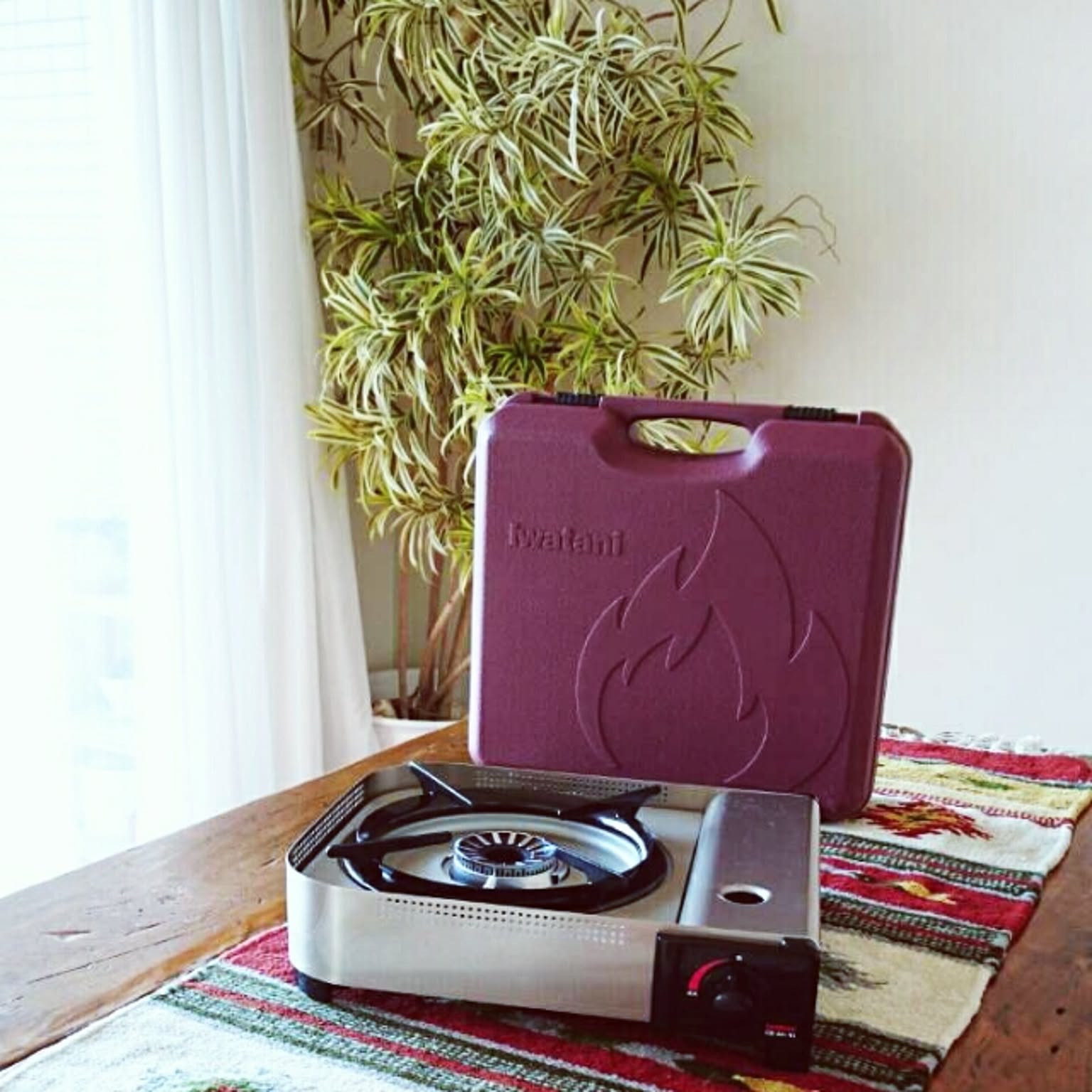 A high-output Iwatani cassette stove with a carrying case on a table.
