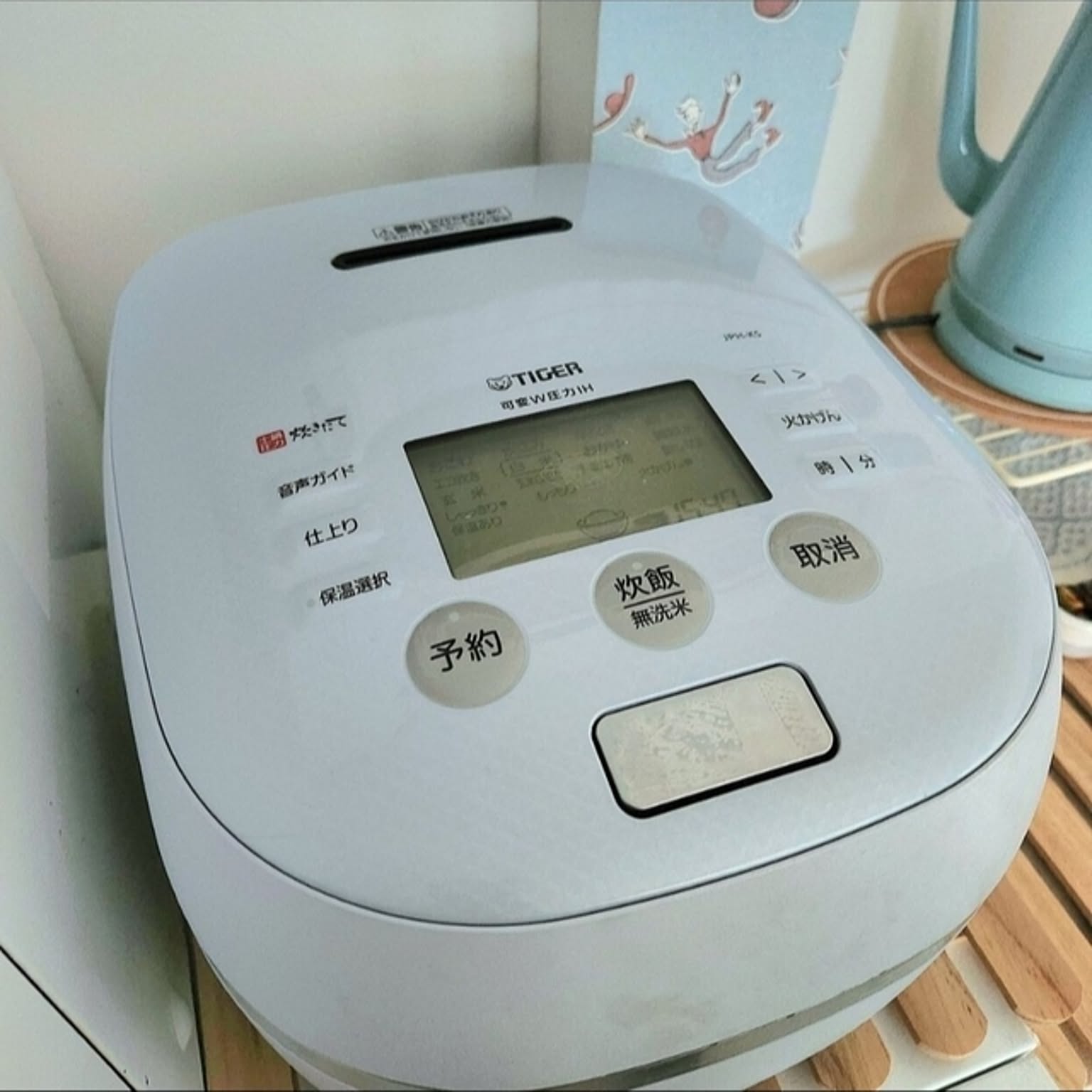 A white Tiger pressure IH rice cooker shown close-up on a kitchen counter.