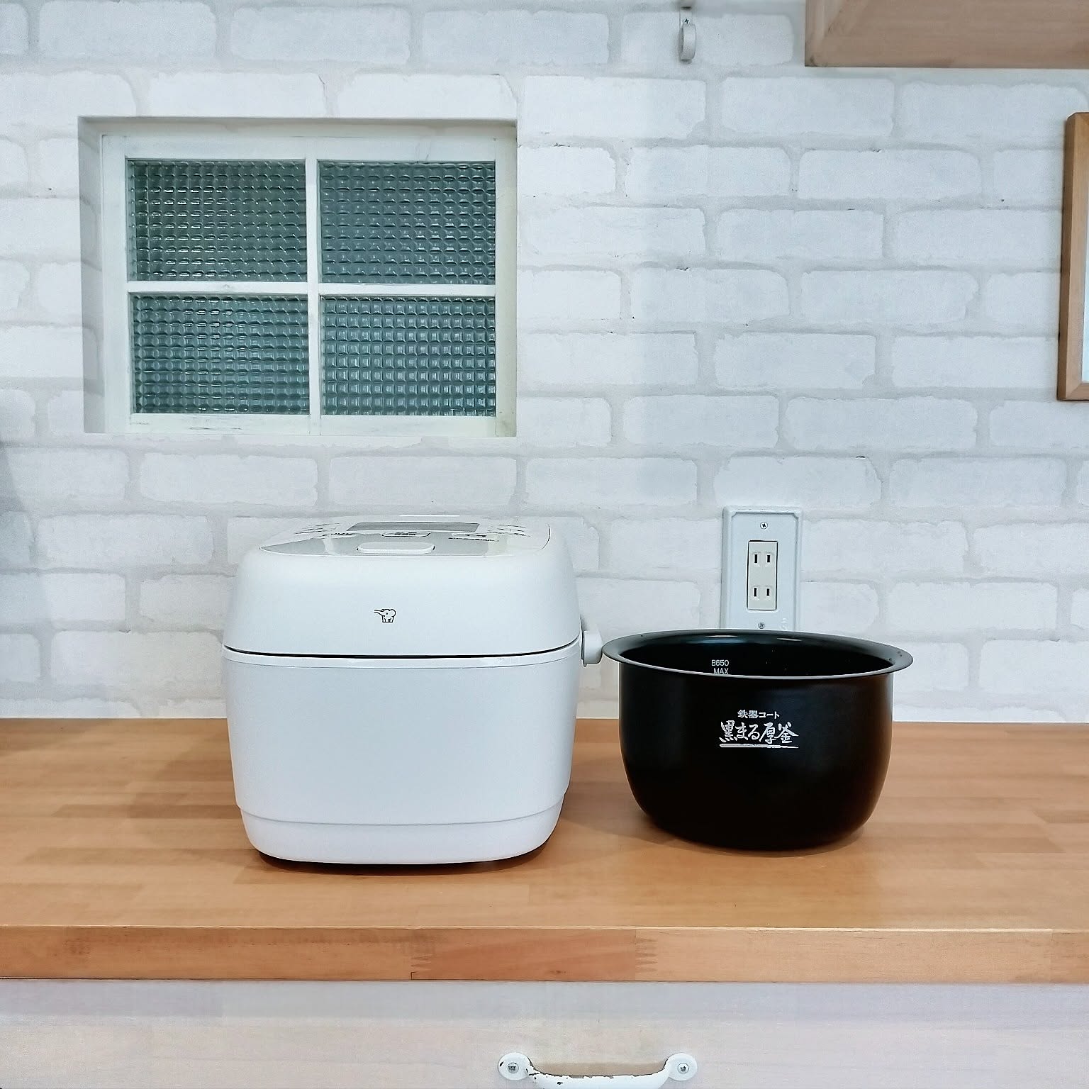 A white Zojirushi pressure IH rice cooker shown open with the inner pot visible.