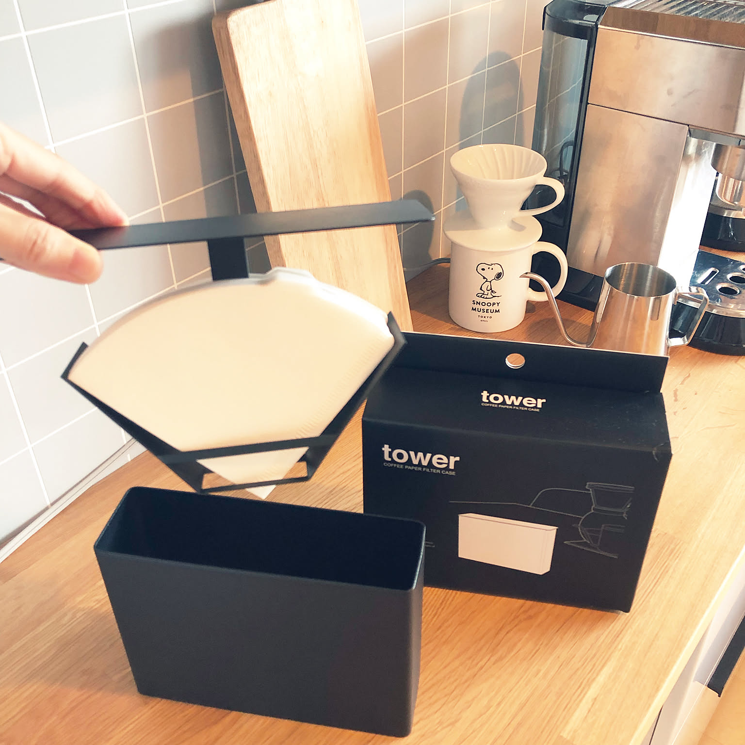 A compact coffee filter case holding Hario V60 paper filters in a Japanese kitchen.