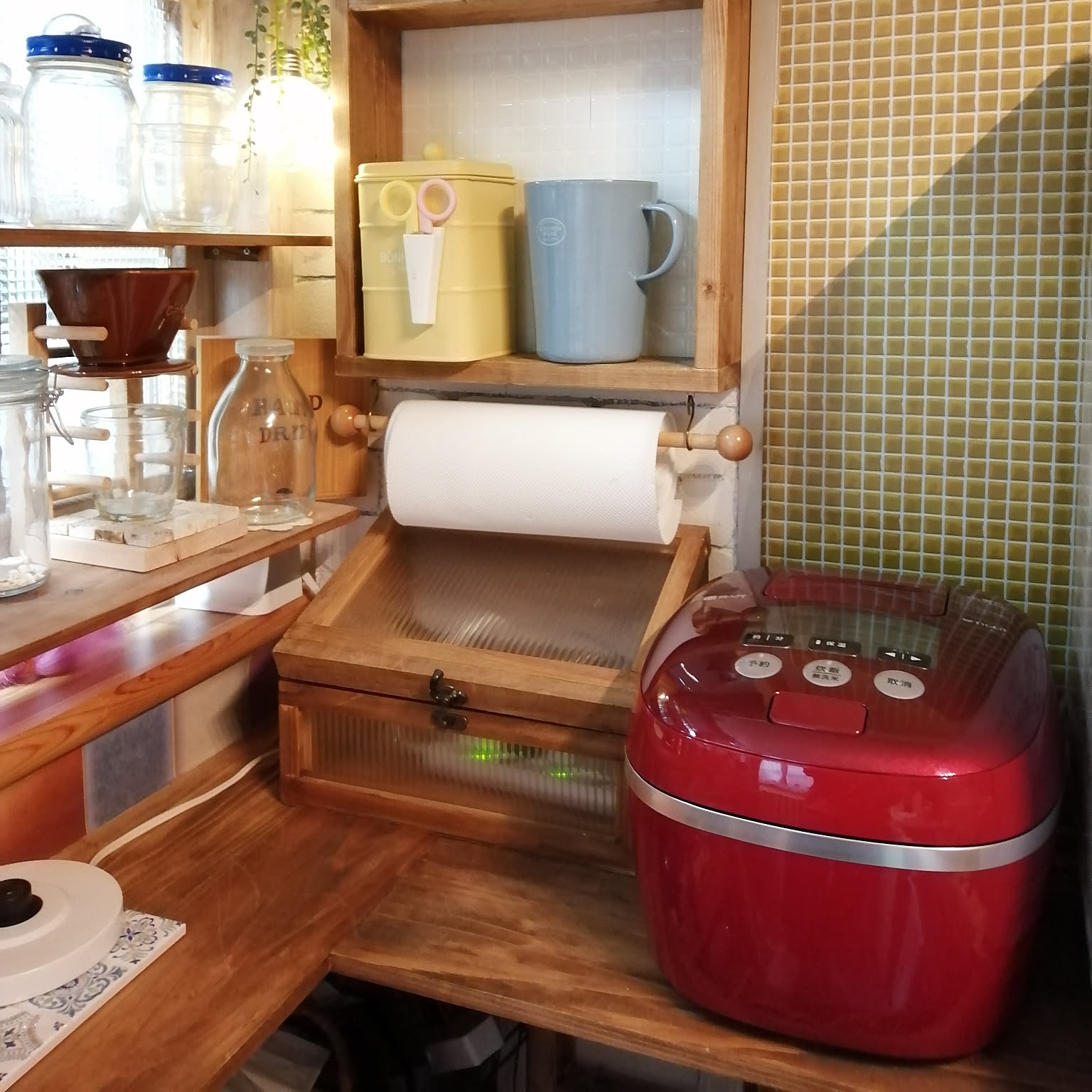 A red Tiger pressure IH rice cooker placed in a warm wood-and-tile kitchen corner.