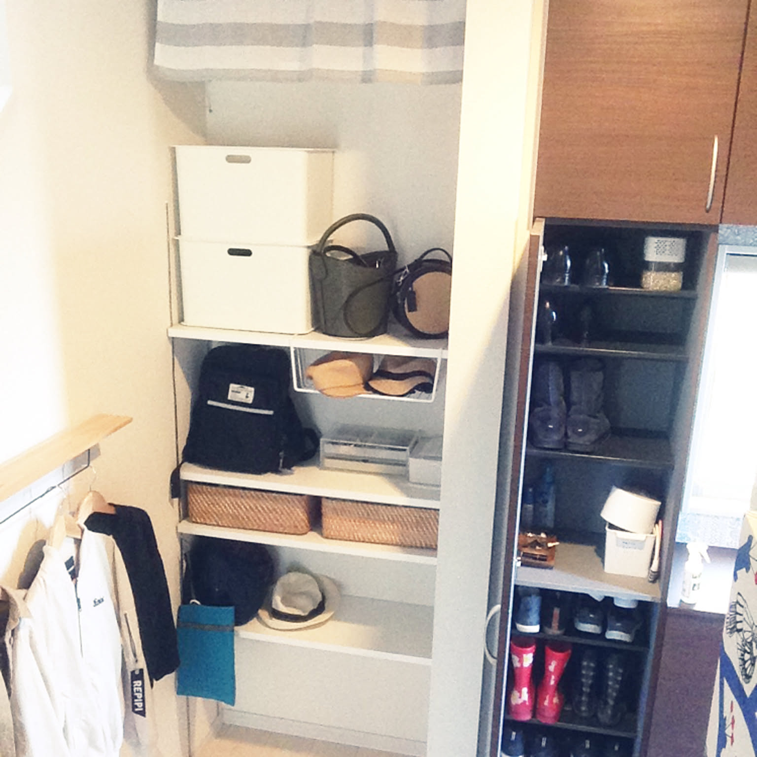 A family entryway storage area with bags, hats, shoe shelves, and small bins arranged near the door.