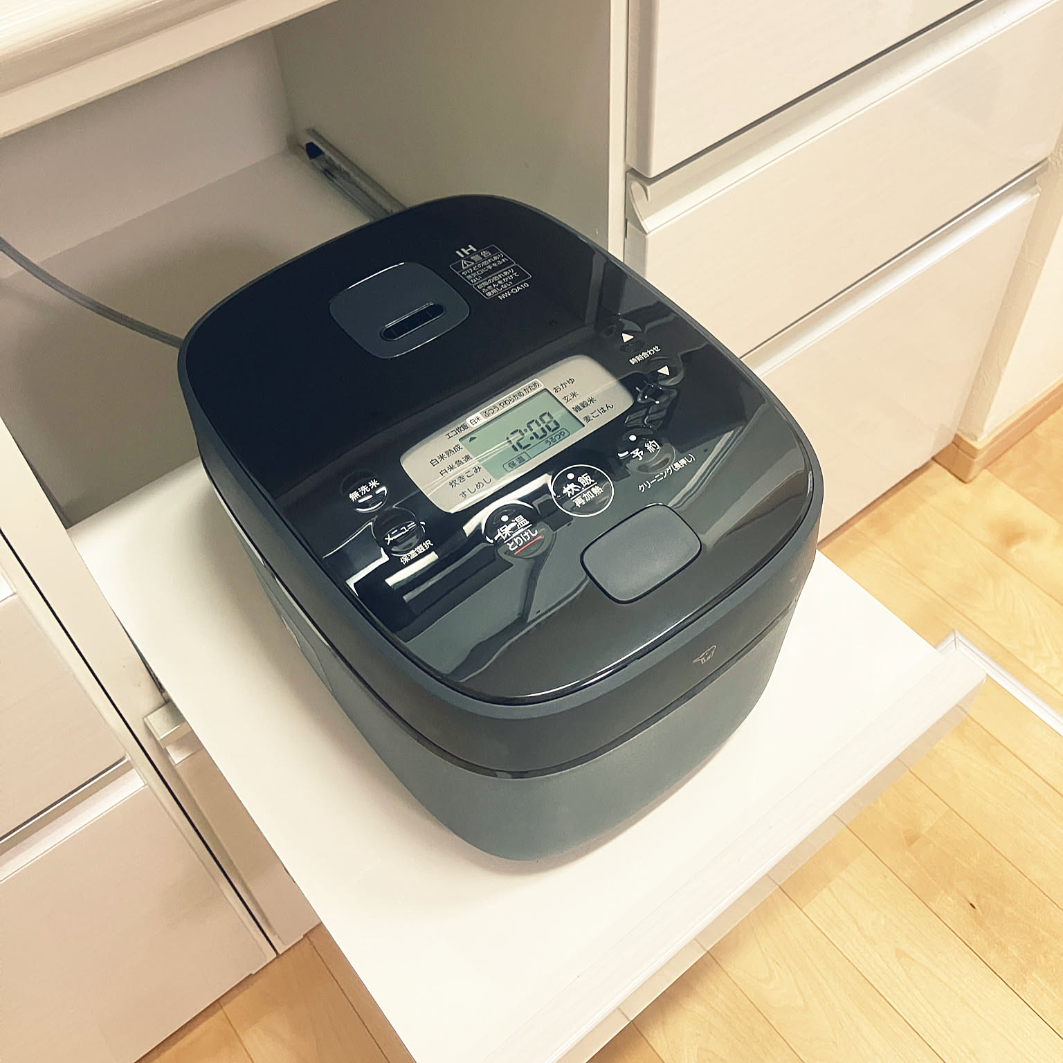 A black Zojirushi NW-QA10-BA 5.5-cup rice cooker shown as the main subject in close-up.