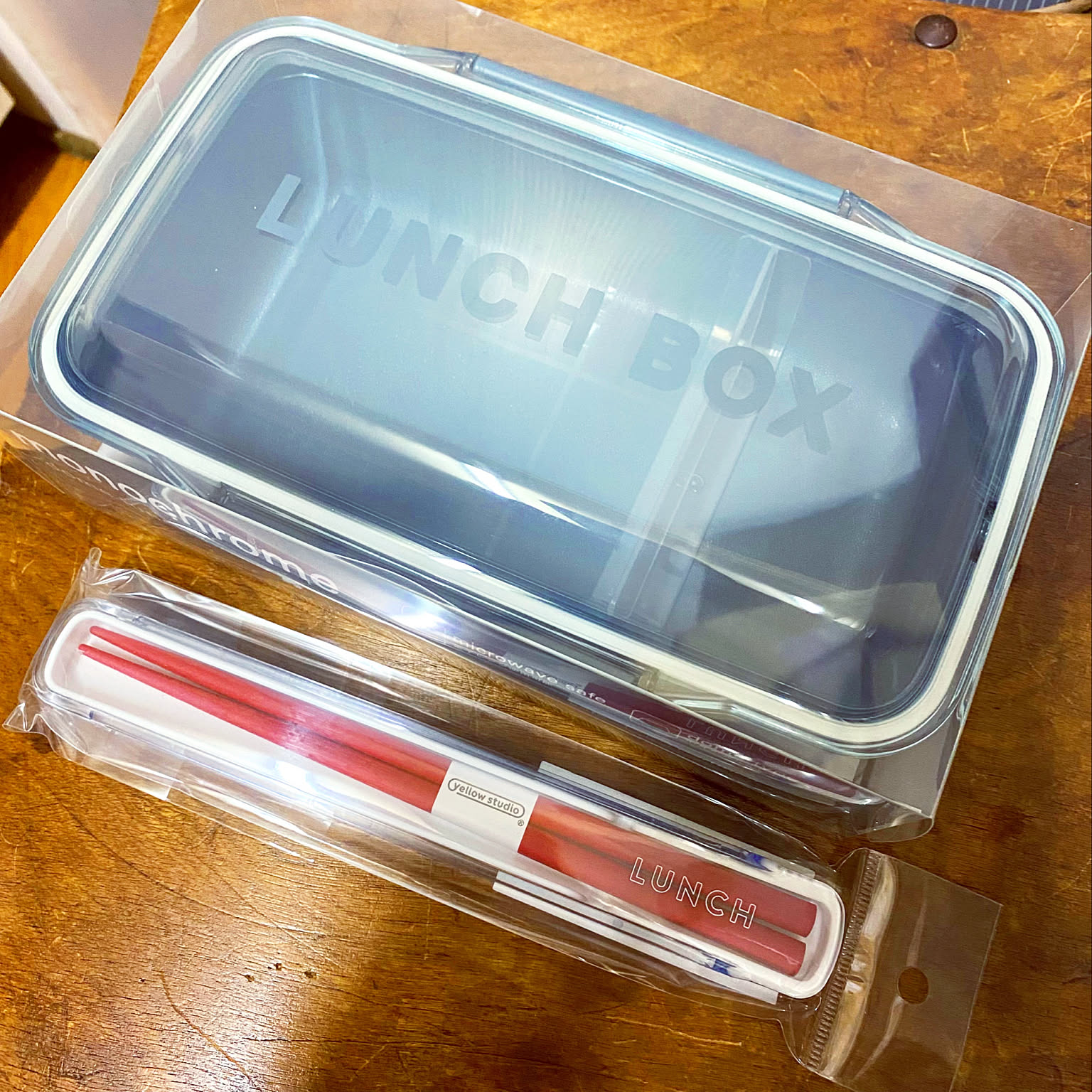 Large gray one-tier bento box shown open with its gasket lid and matching chopstick case.