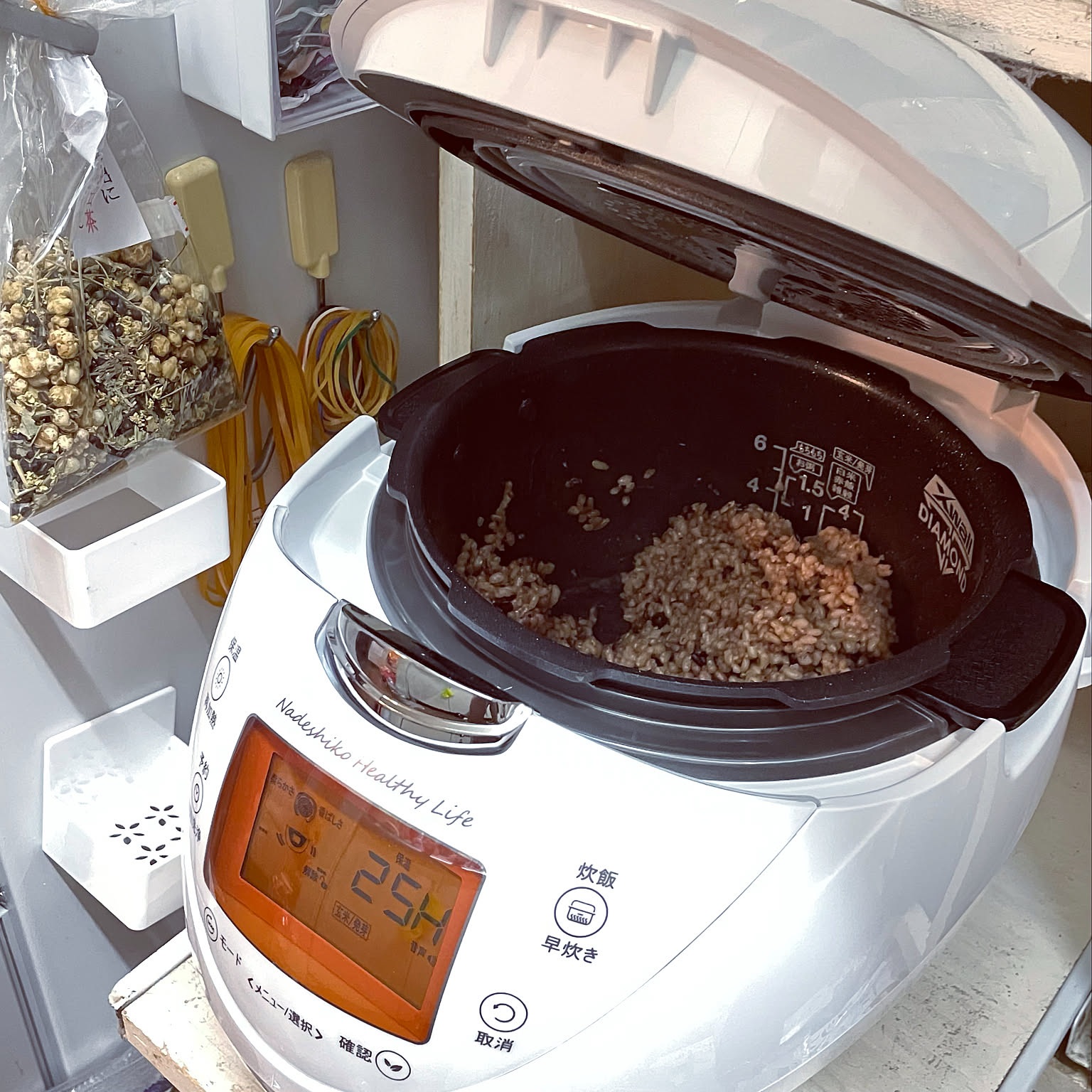A brown-rice-focused countertop cooker shown close-up in a Japanese kitchen.
