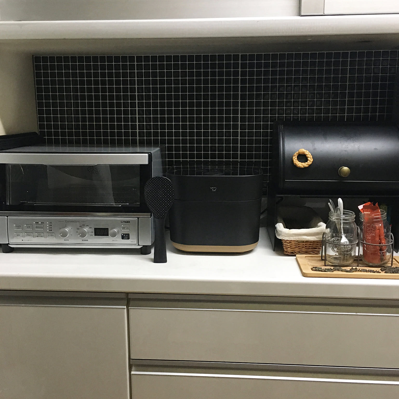 A black Zojirushi STAN. 5.5-cup rice cooker shown on a tidy counter with leftover-friendly storage nearby.